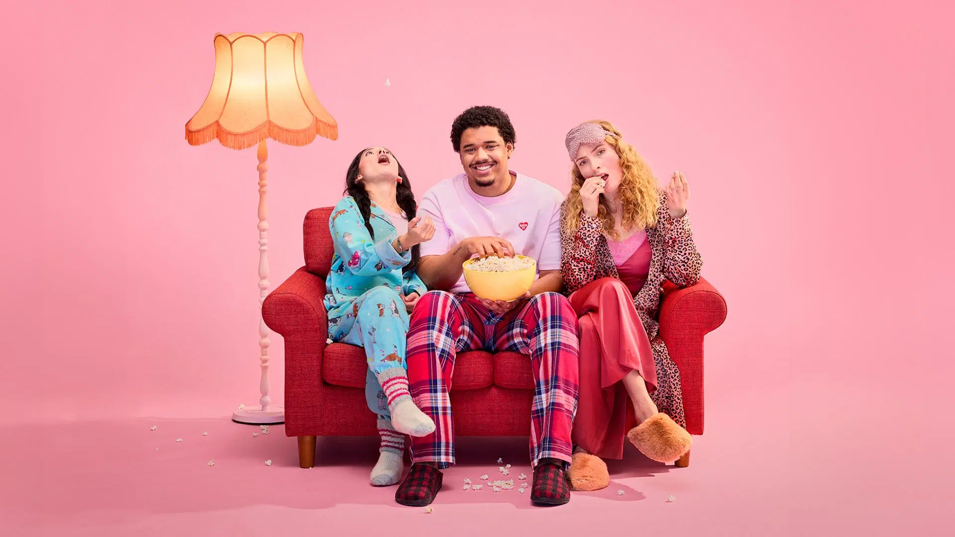 Ystävykset istuvat sohvalla