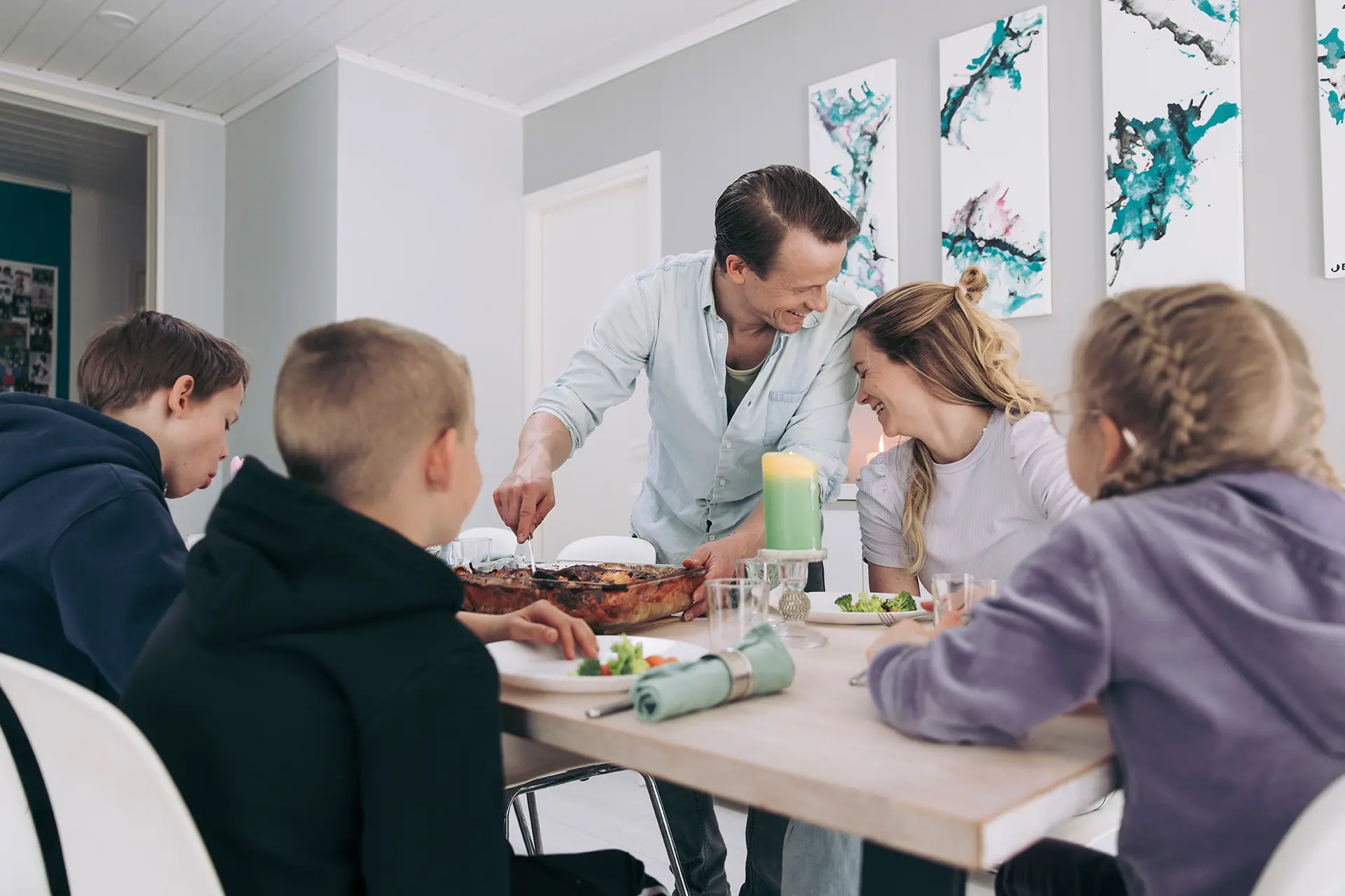 Konsta ja Aami Hietanen perheineen syömässä lasagnea.