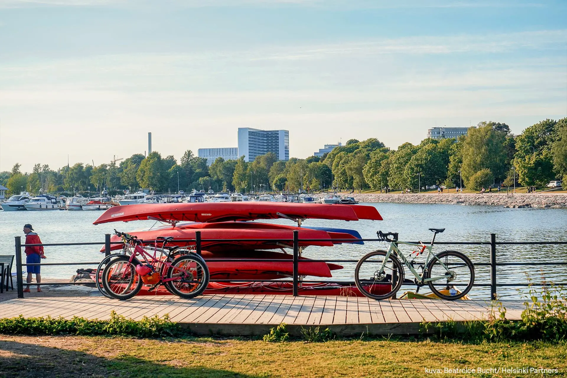 Punaisia kanootteja pinossa meren rannalla Töölössä.