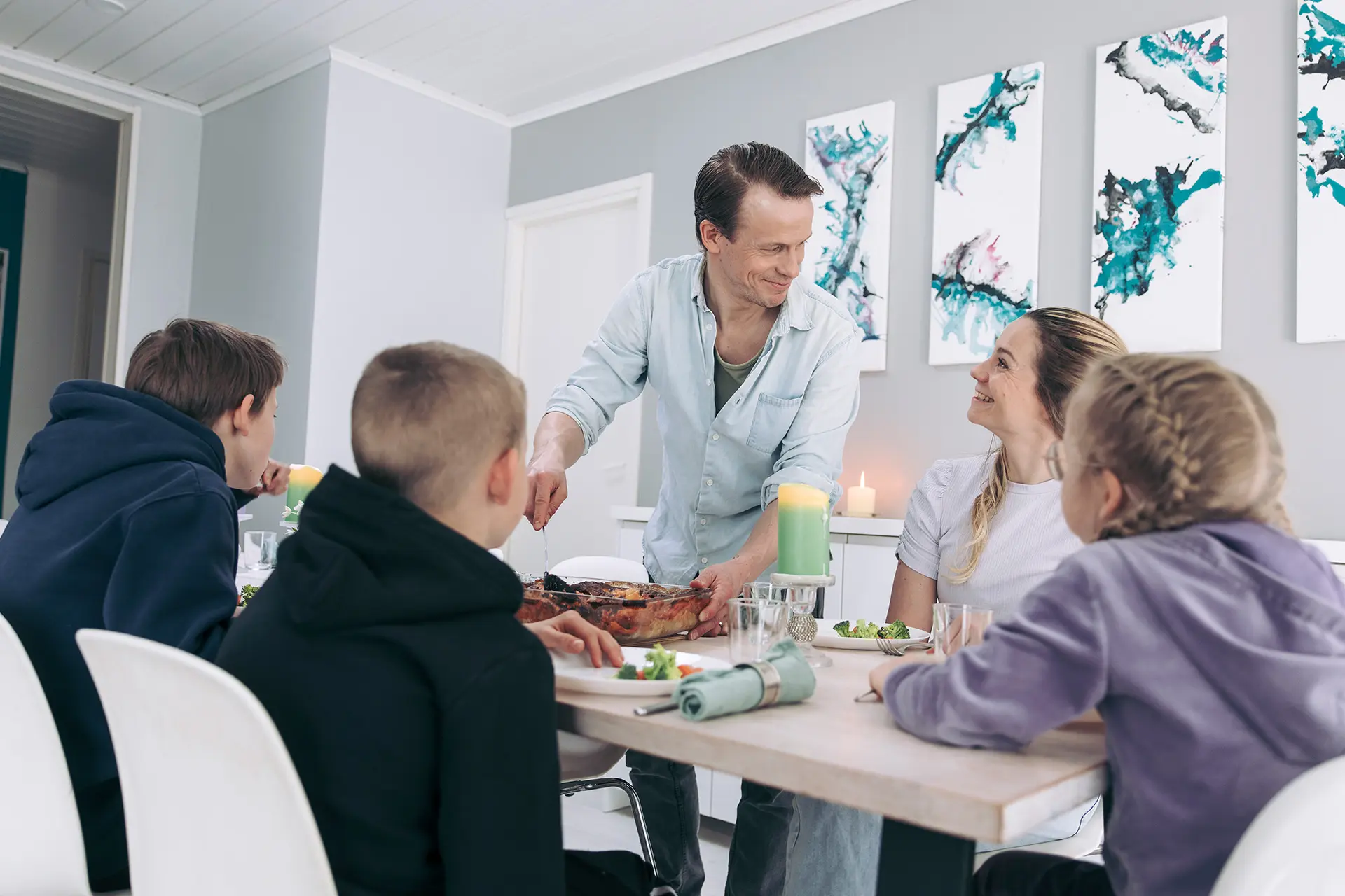 Konsta ja Aami Hietanen perheineen syömässä lasagnea.