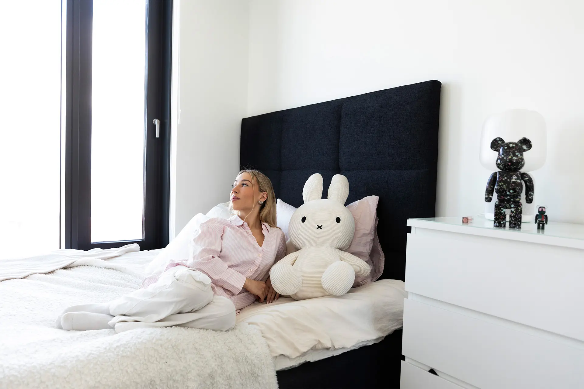 Nelli Orell vuoteella, vieressä suuri pehmojänis.