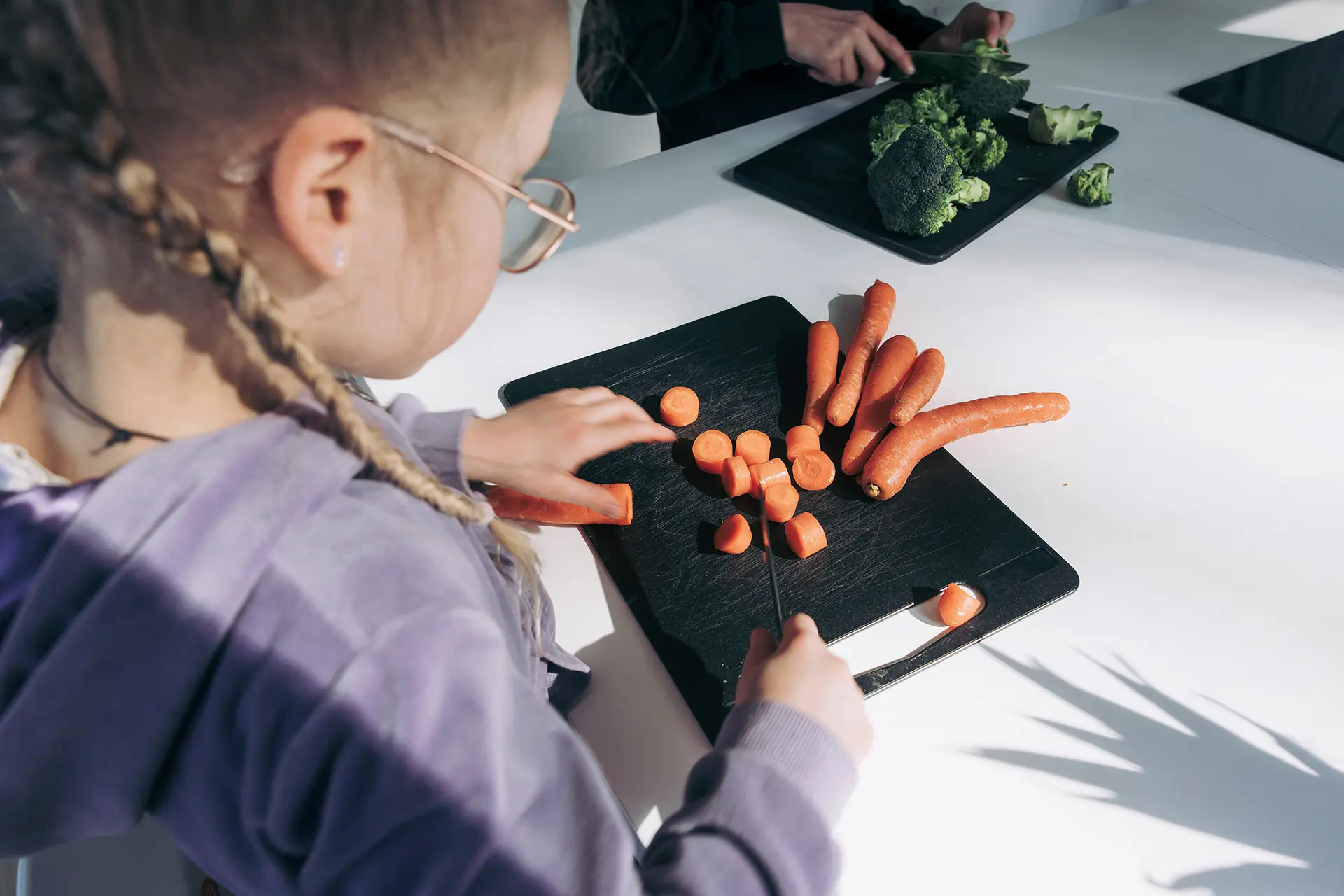 Lapsi pilkkoo porkkanoita.