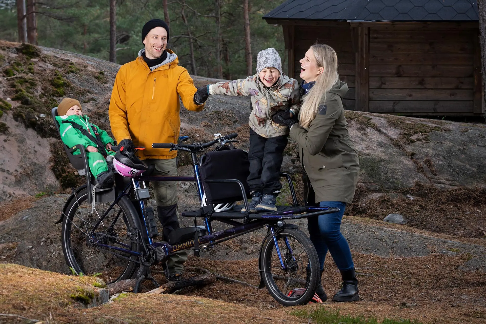 Nelihenkinen perhe tavarapyörän kanssa