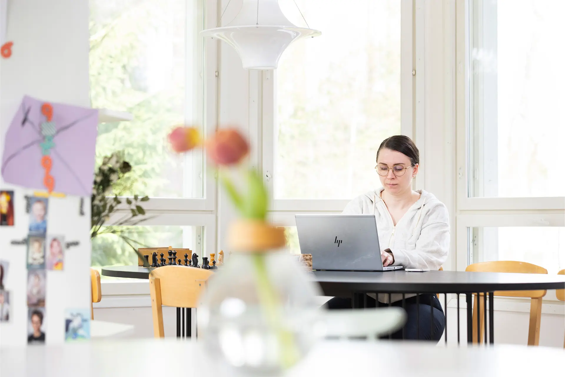 Henni Malmberg istuu pöydän ääressä, edessä tietokone.