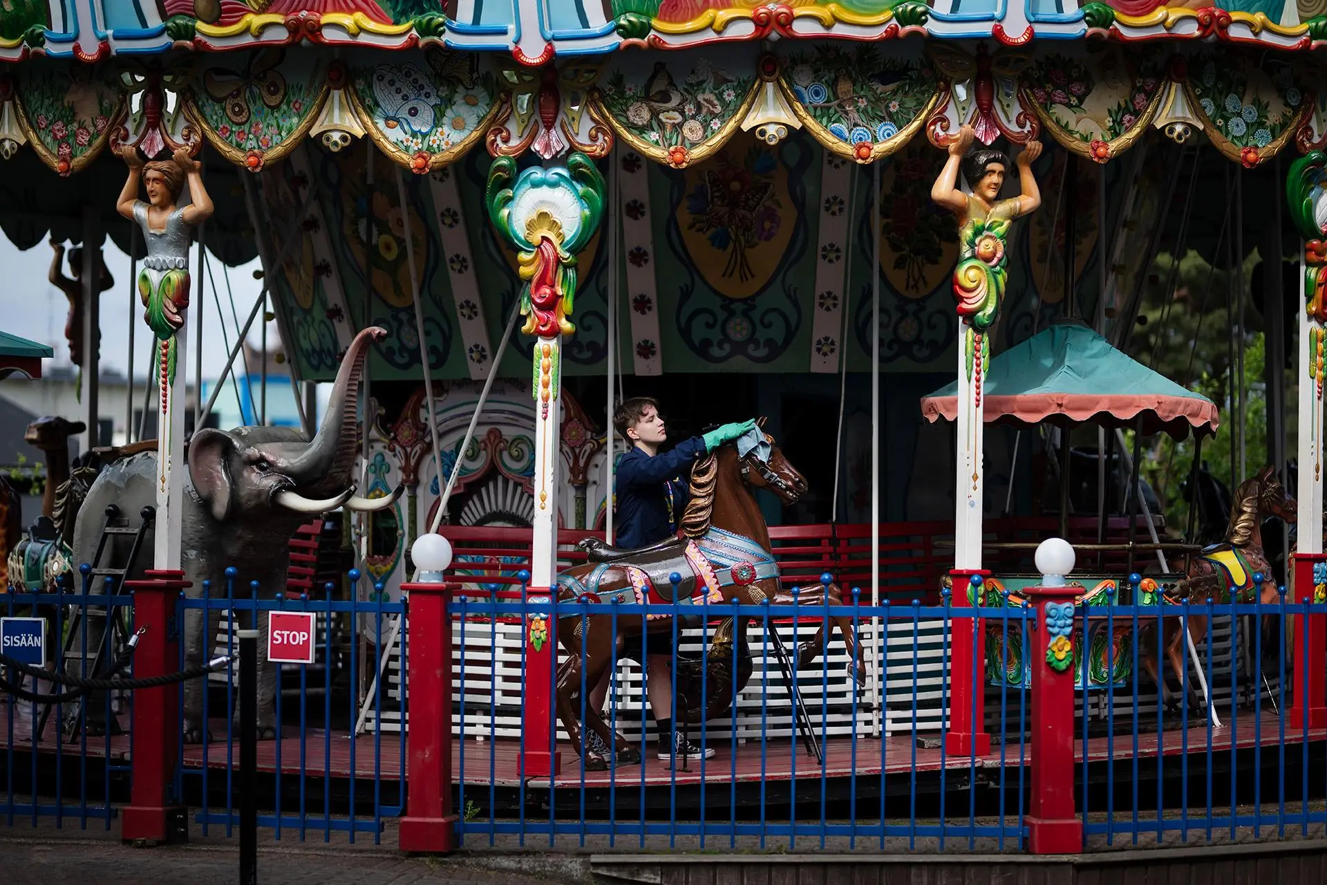 Puhtaanapidon vuoroesihenkilö Lilli Lauri pyyhkii karusellihevosta.