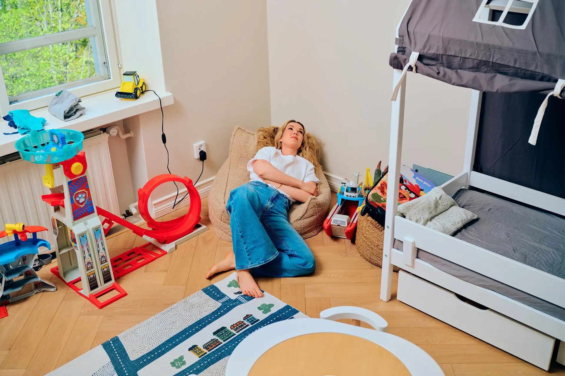 Tuija Pehkonen makoilee lastenhuoneessa pienellä säkkituolilla.