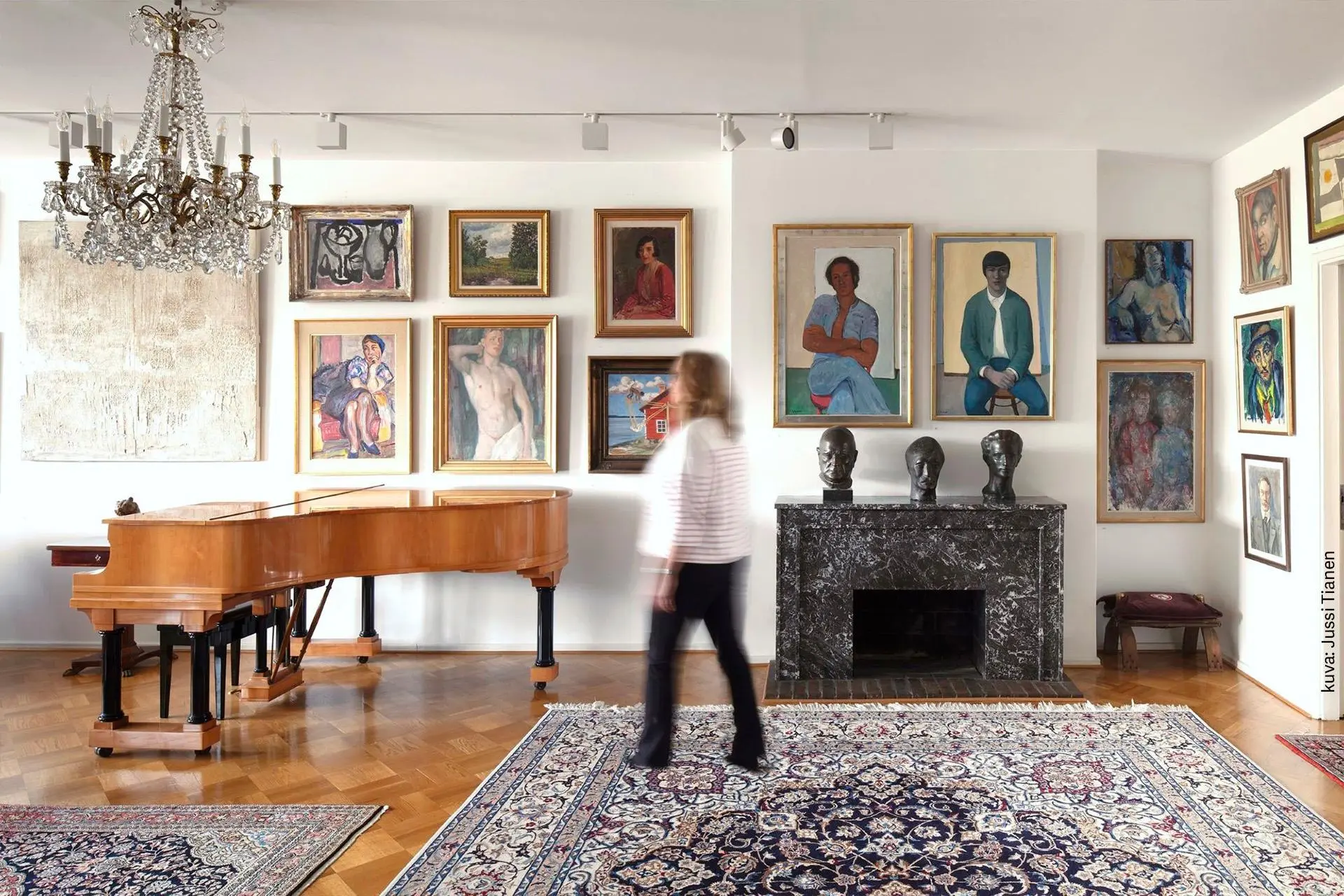 Nainen selin taidekoti Kirpilän teosten edessä.