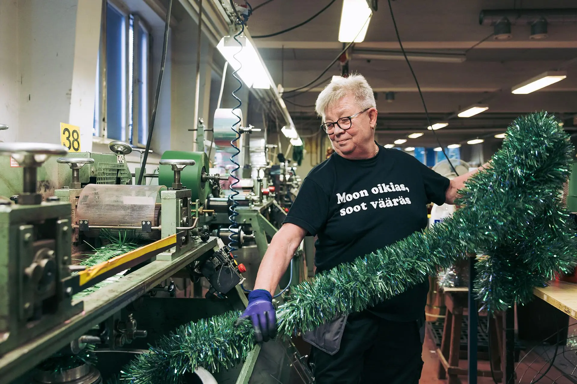 Jaana Turunen ottaa koristeköynnöksen tehdaskoneesta