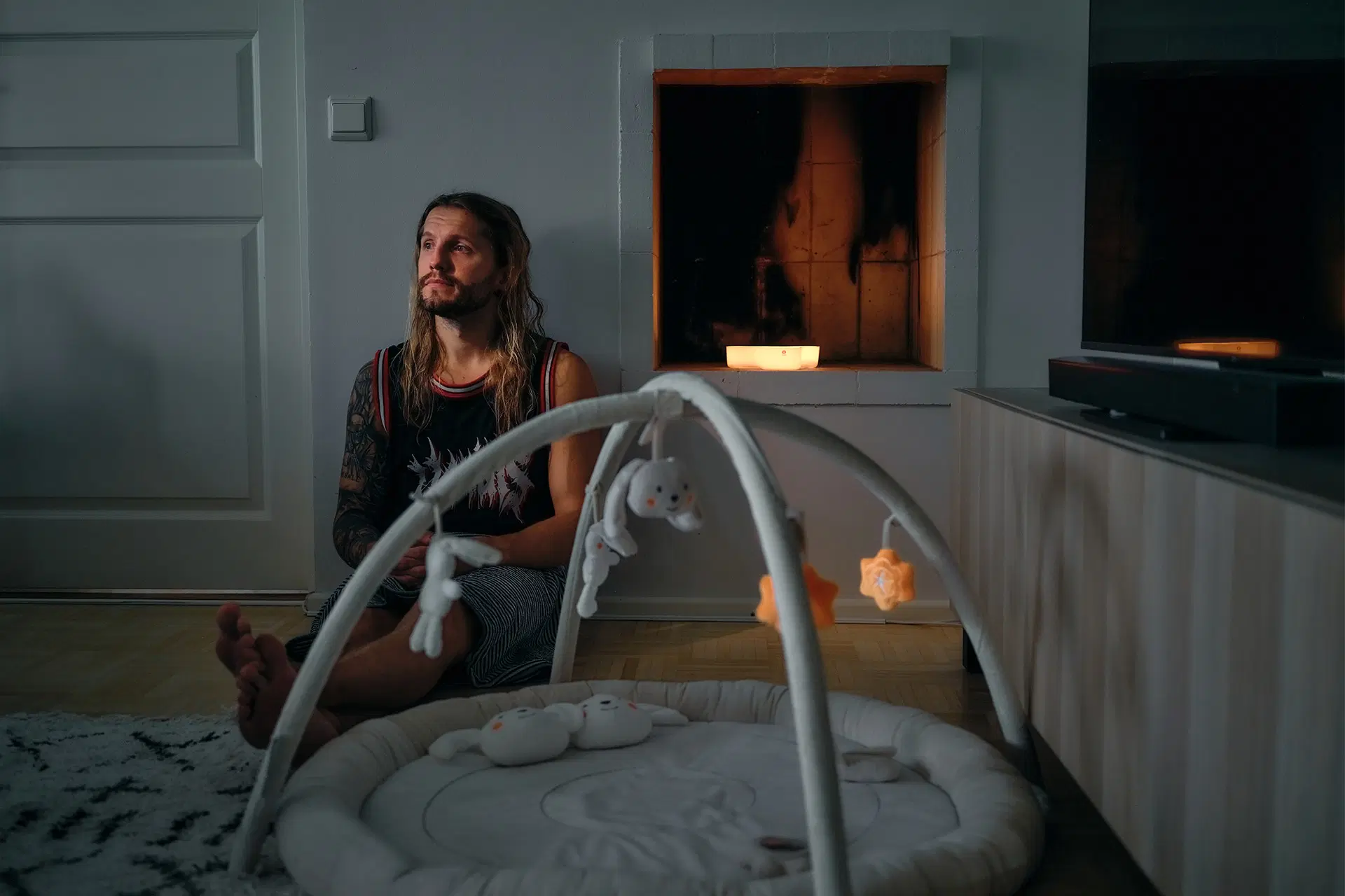 Aapo Vuori i vardagsrummet. På golvet ligger an babylekmatta.