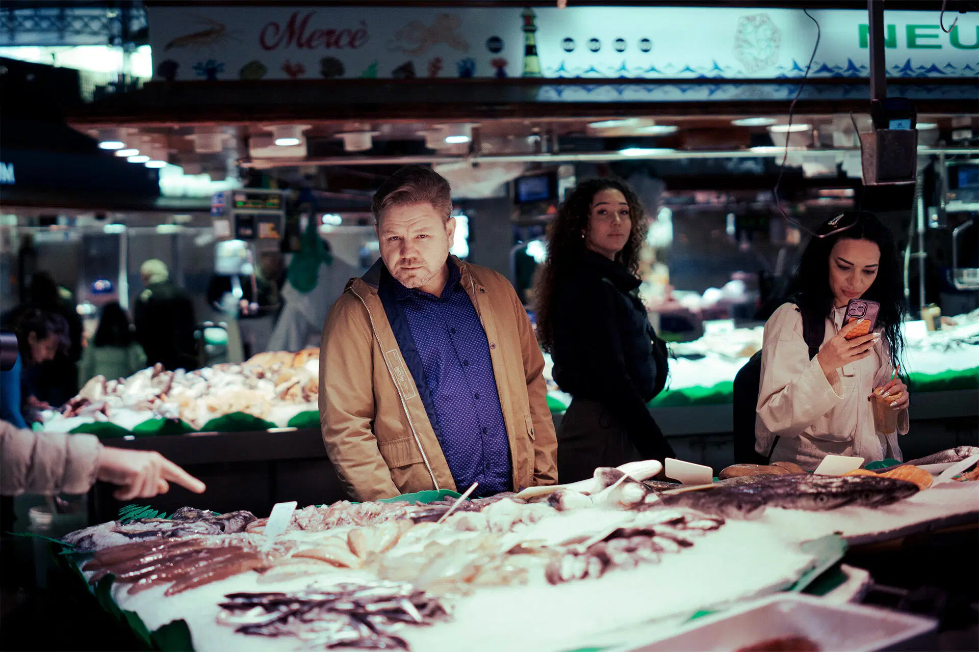 Kokki Jani Paasikoski katsoo kameraan kauppahallin käytävällä, kalatiskin edessä..