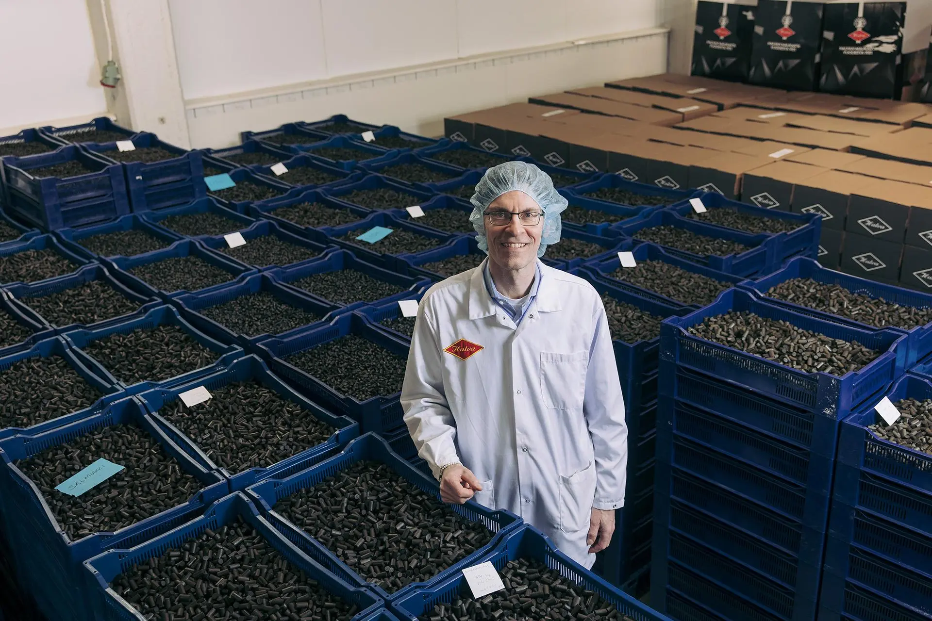 Mies seisoo lakulaatikoiden keskellä.