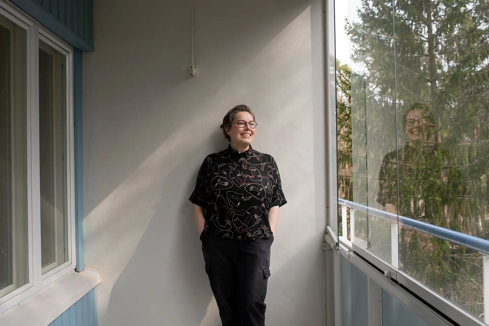 Kitti Suoranta seisoo kerrostaloasunnon parvekkeella.