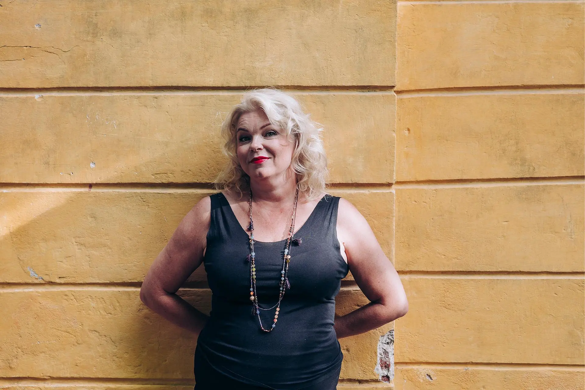 Anne Moilanen nojaa seinään.