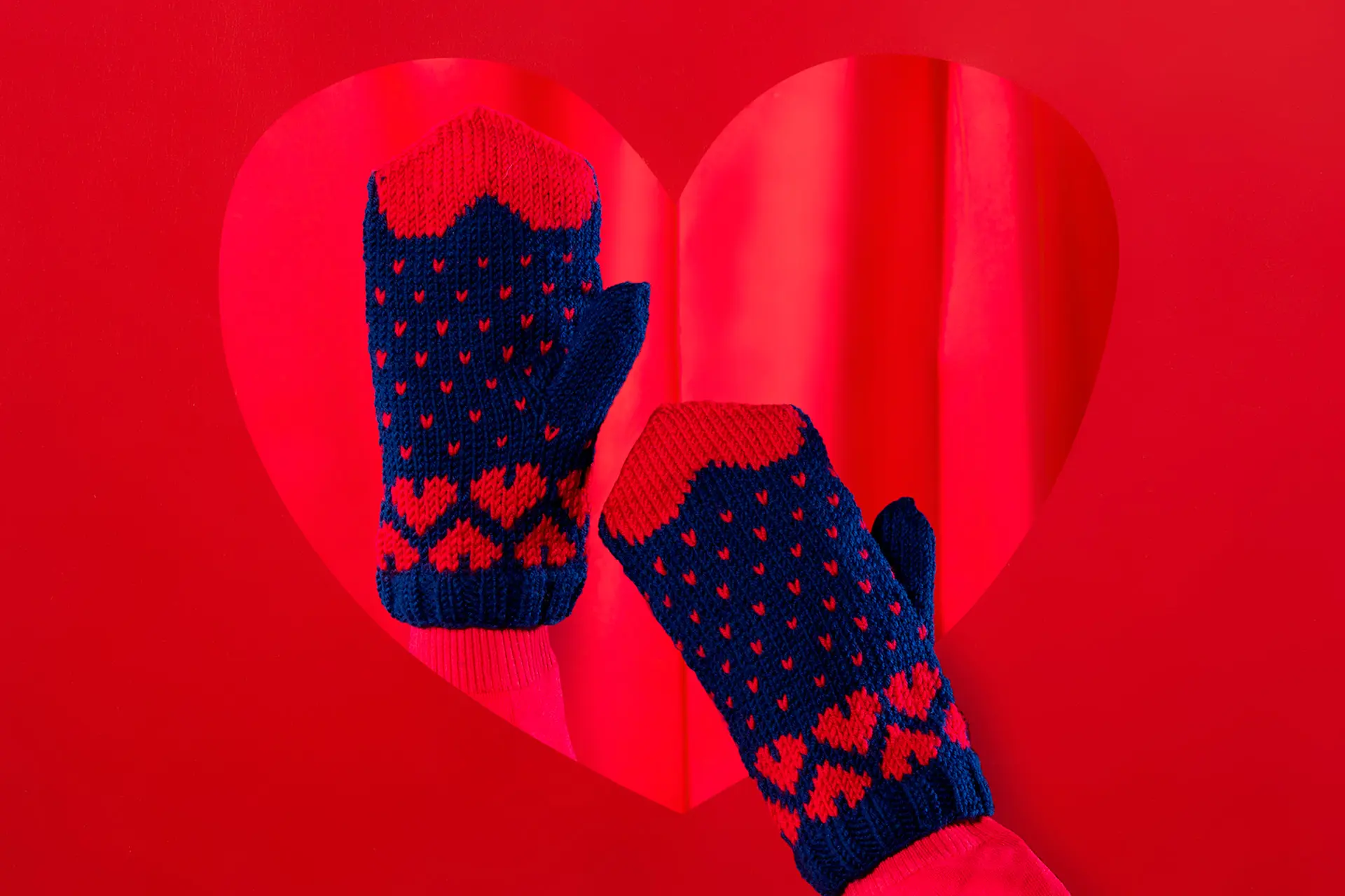 Sydämin kuvioidut lapaset, joista toinen on puettu käteen.