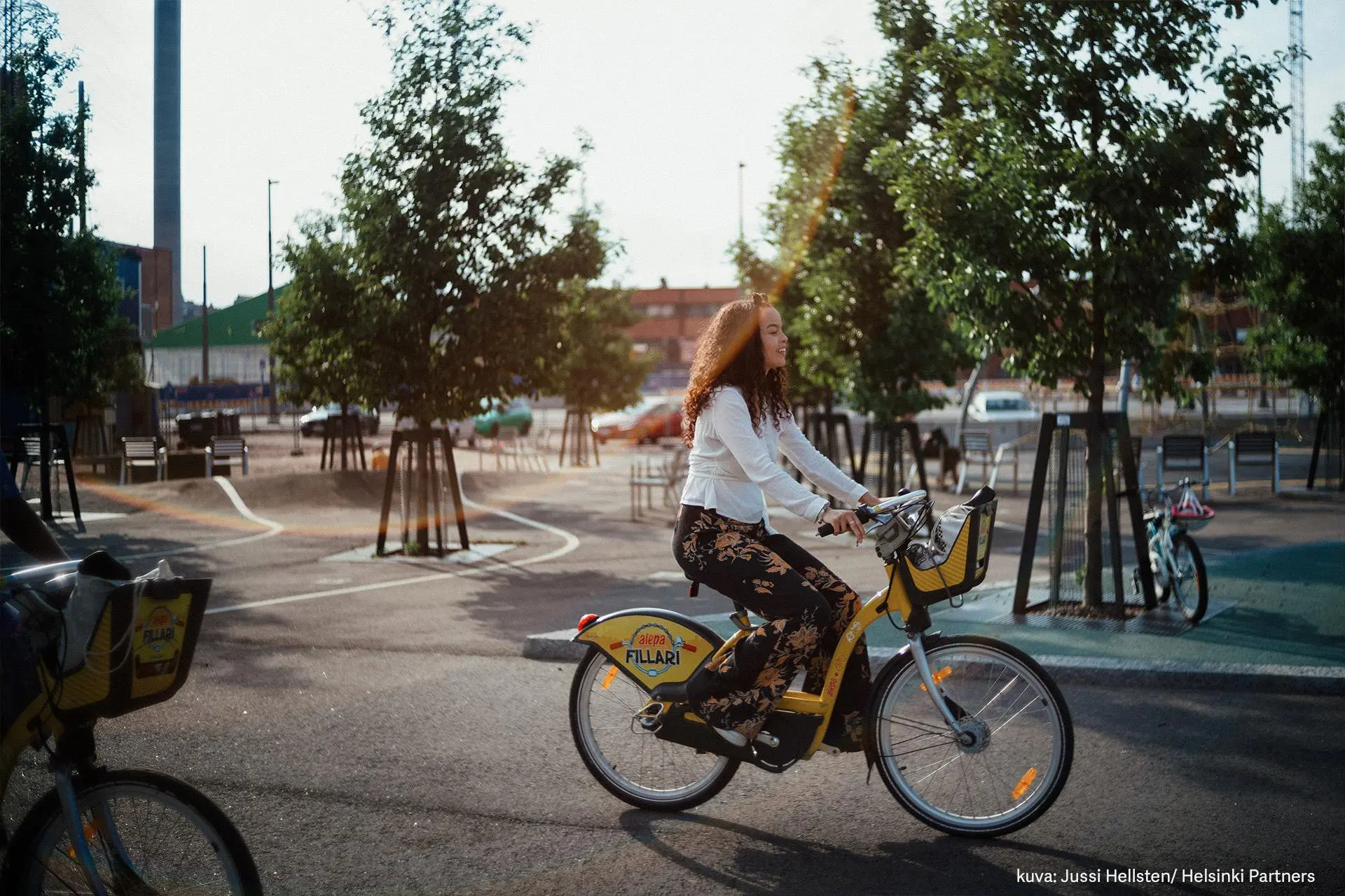 Nuori nainen ajaa Alepa-pyörällä Kalasatamassa.