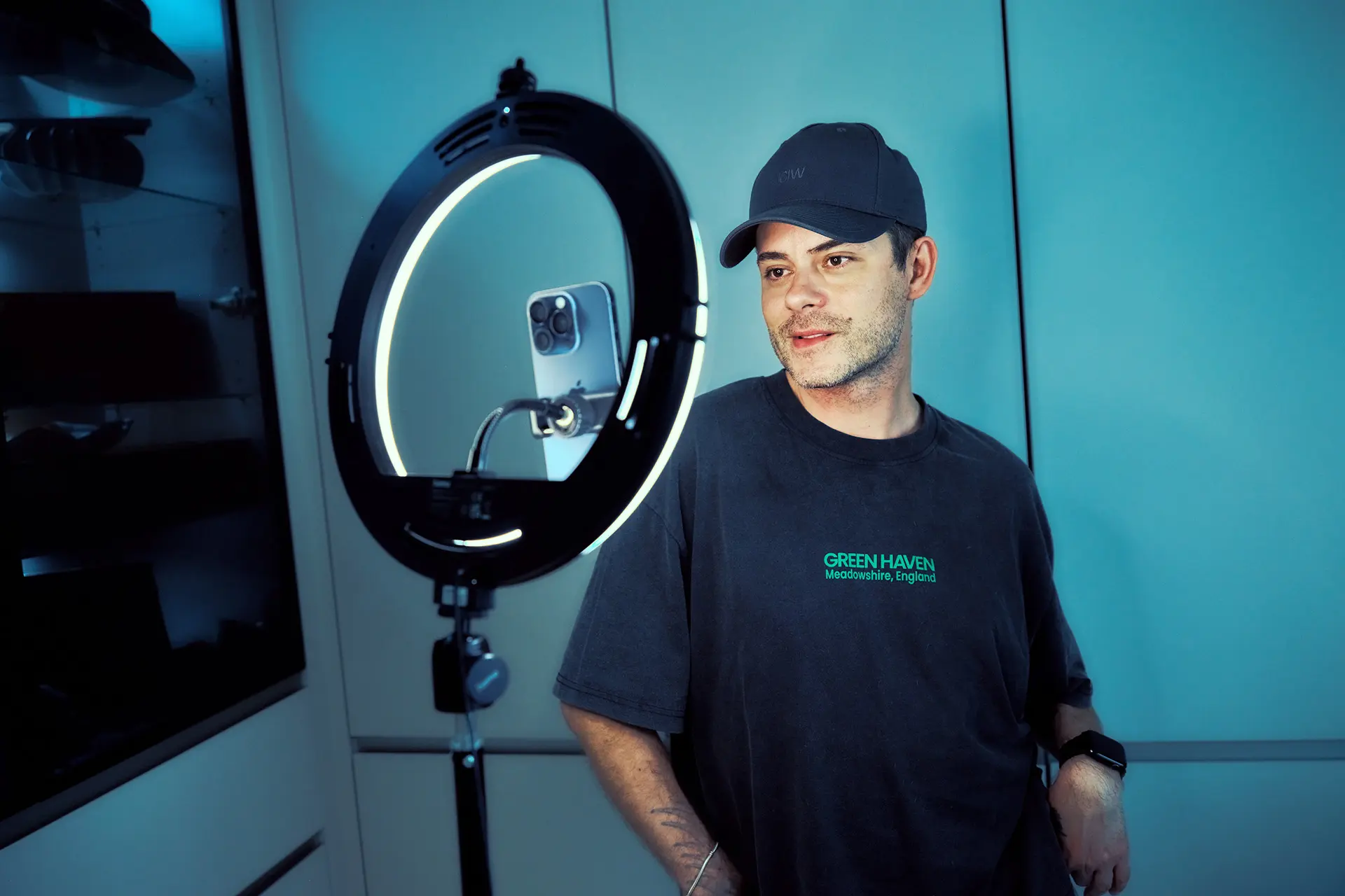 Niko Saarinen ringlightin edessä. Valoon on kiinnitetty kännykkä.