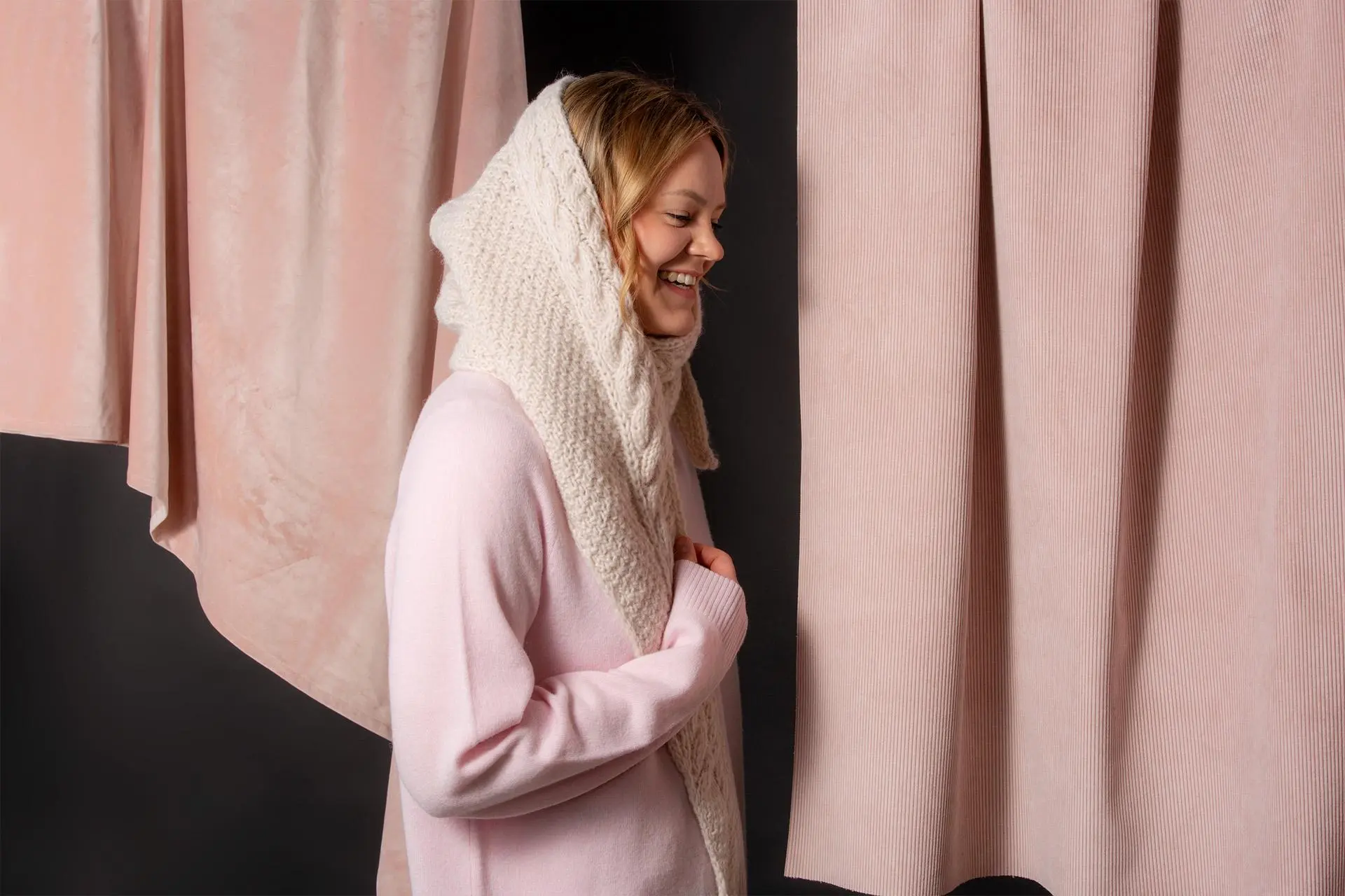 Nainen, jolla on yllään huppumaisesti pään ympäri kietaistu villahuivi.