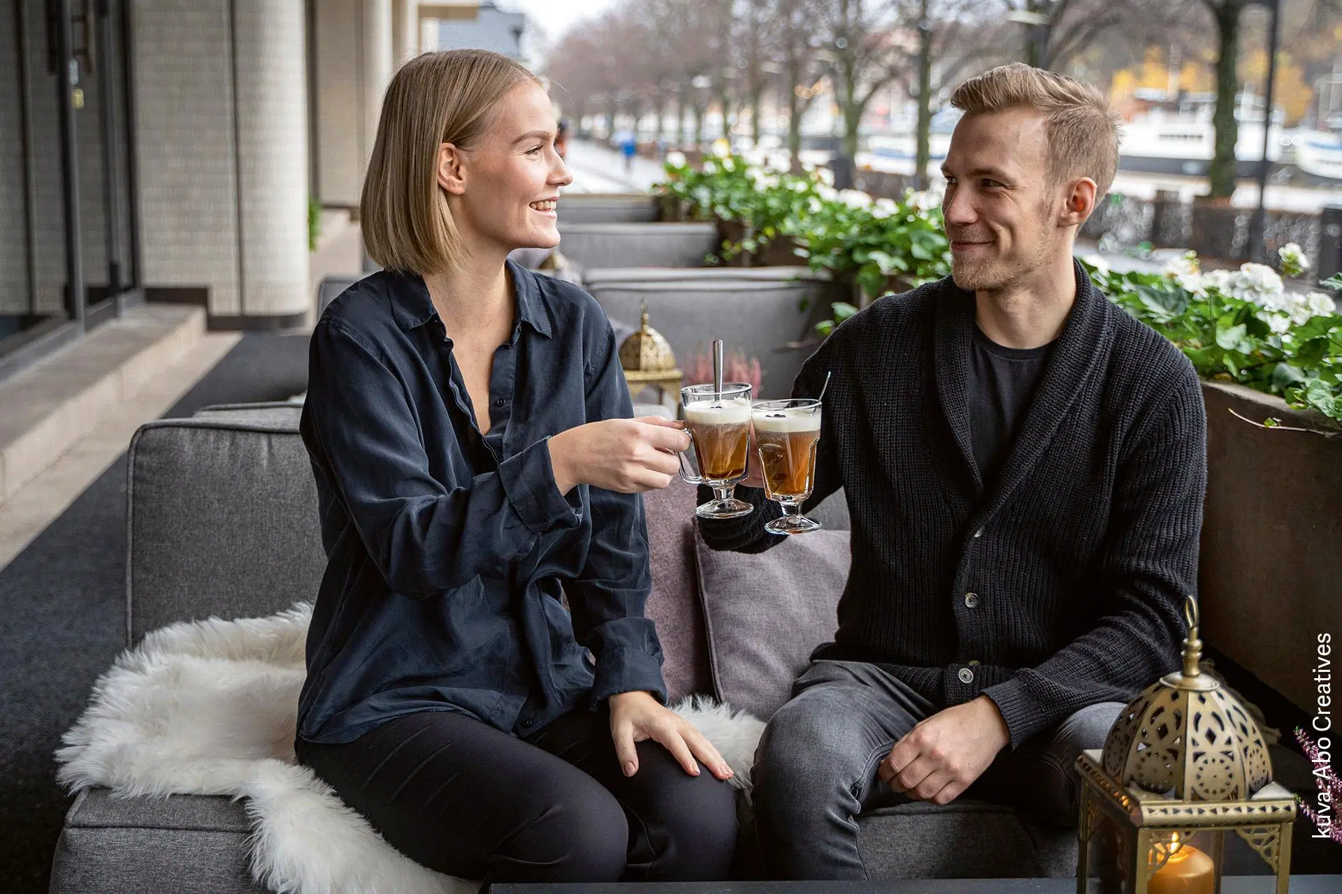 Mies ja nainen juovat lämpimiä juomia Turun Aurajoen varrella sijaitsevassa ravintolassa