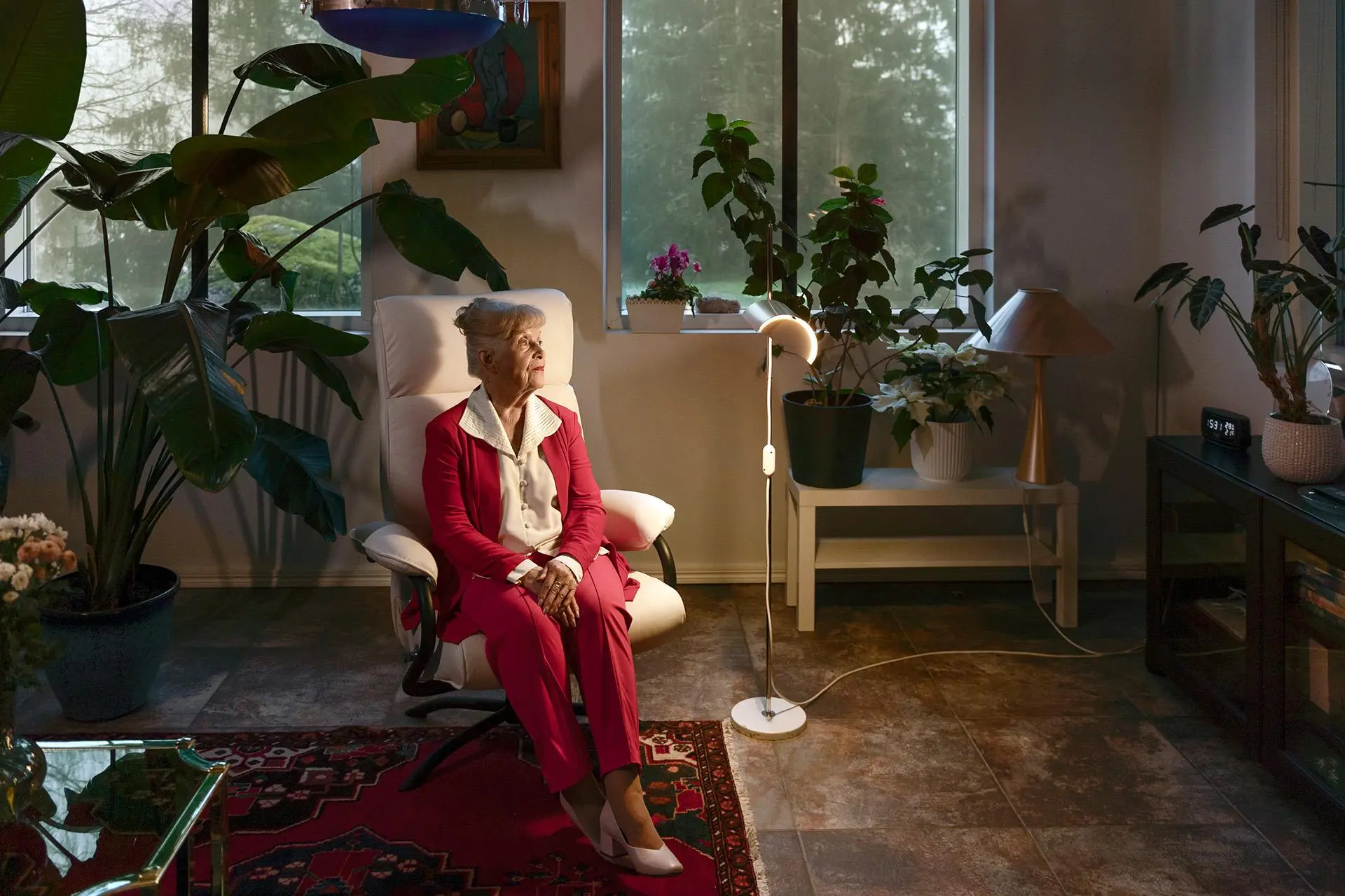 Pirjo Tuominen istuu kotinsa alakerrassa tuolilla.