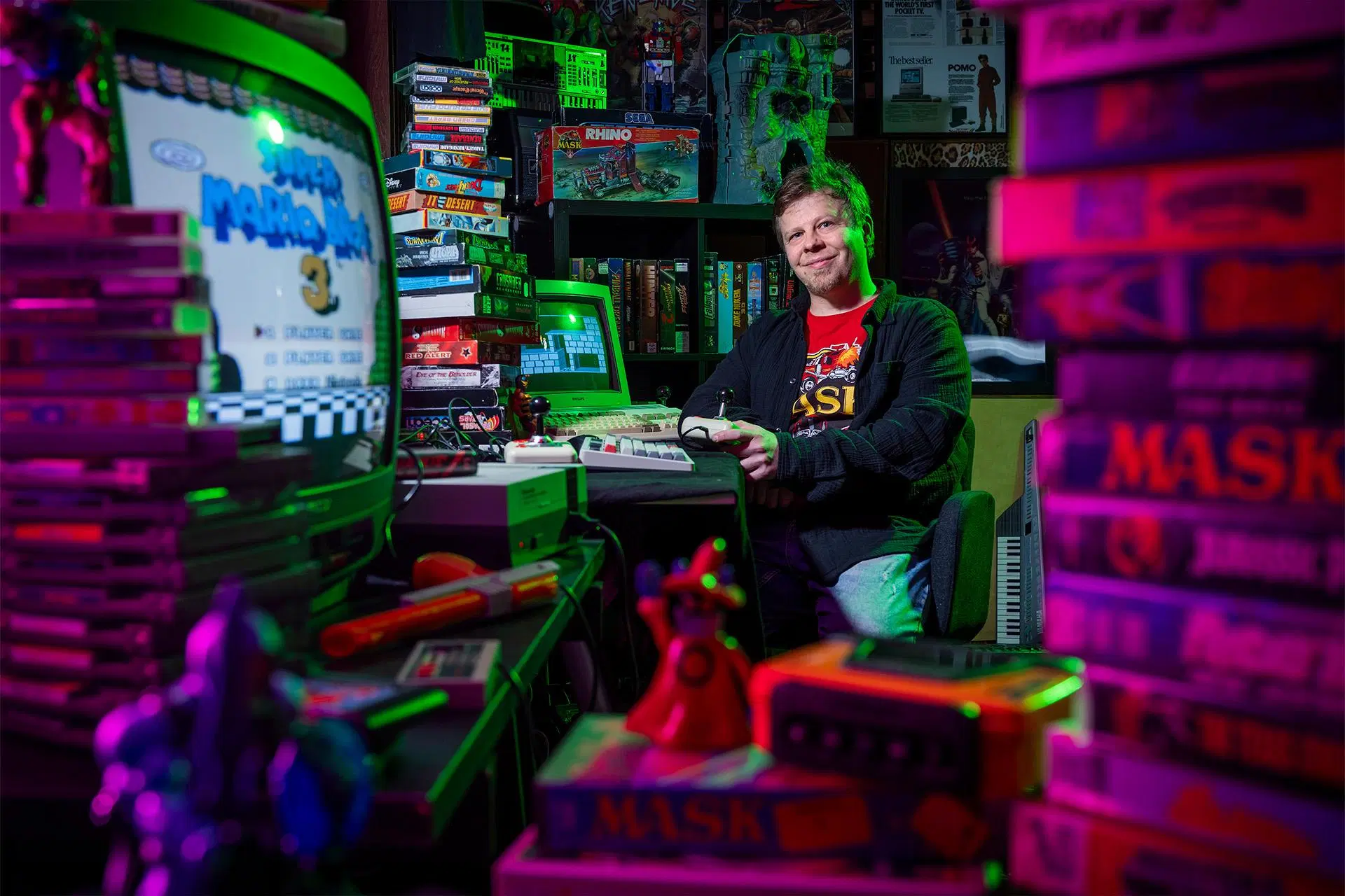 Lauri Turjansalo pelaa vanhalla pelikonsolilla huoneessa, joka on täynnä videopelejä.