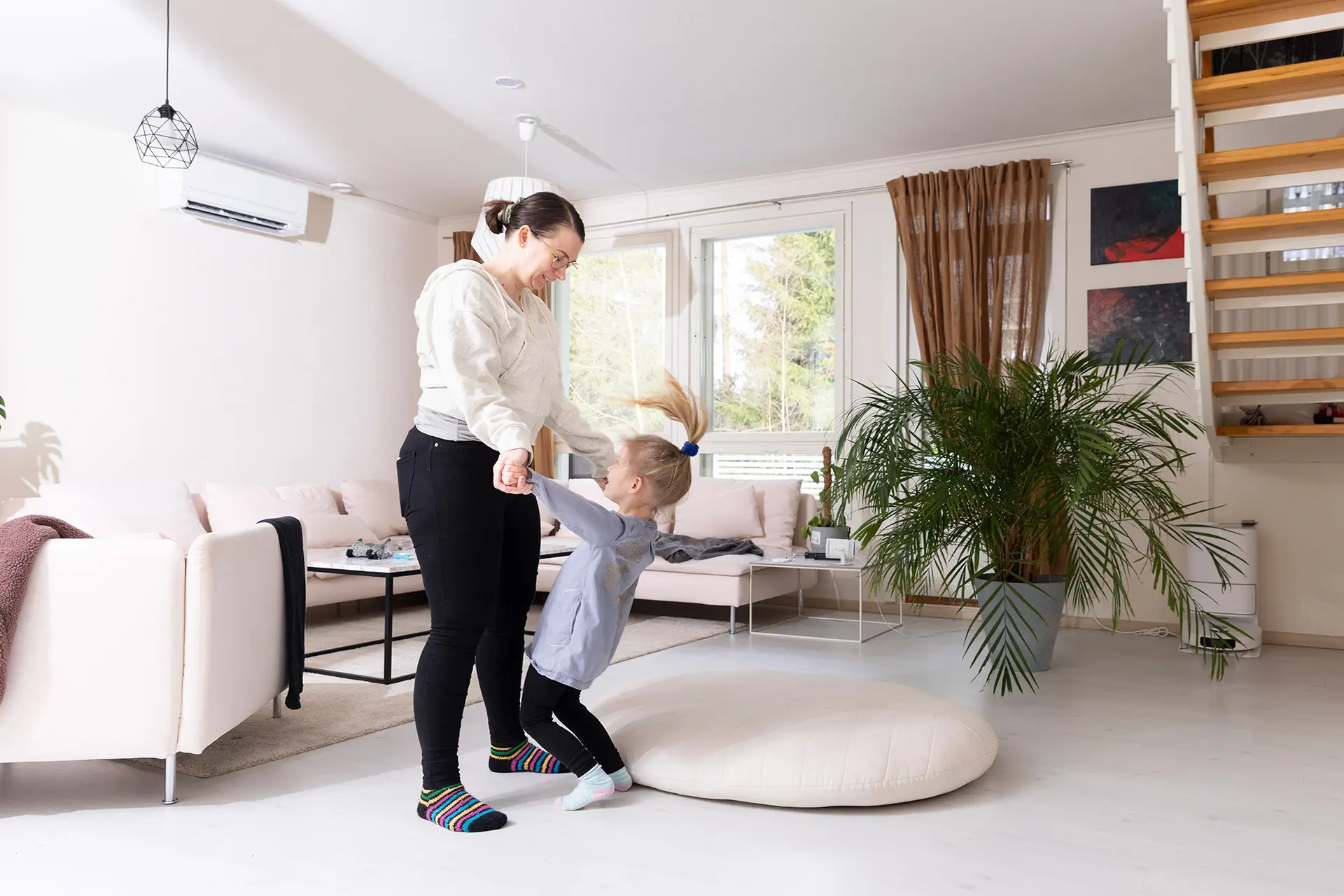 Henni Malmberg ja hänen tyttärensä leikkivät olohuoneessa.