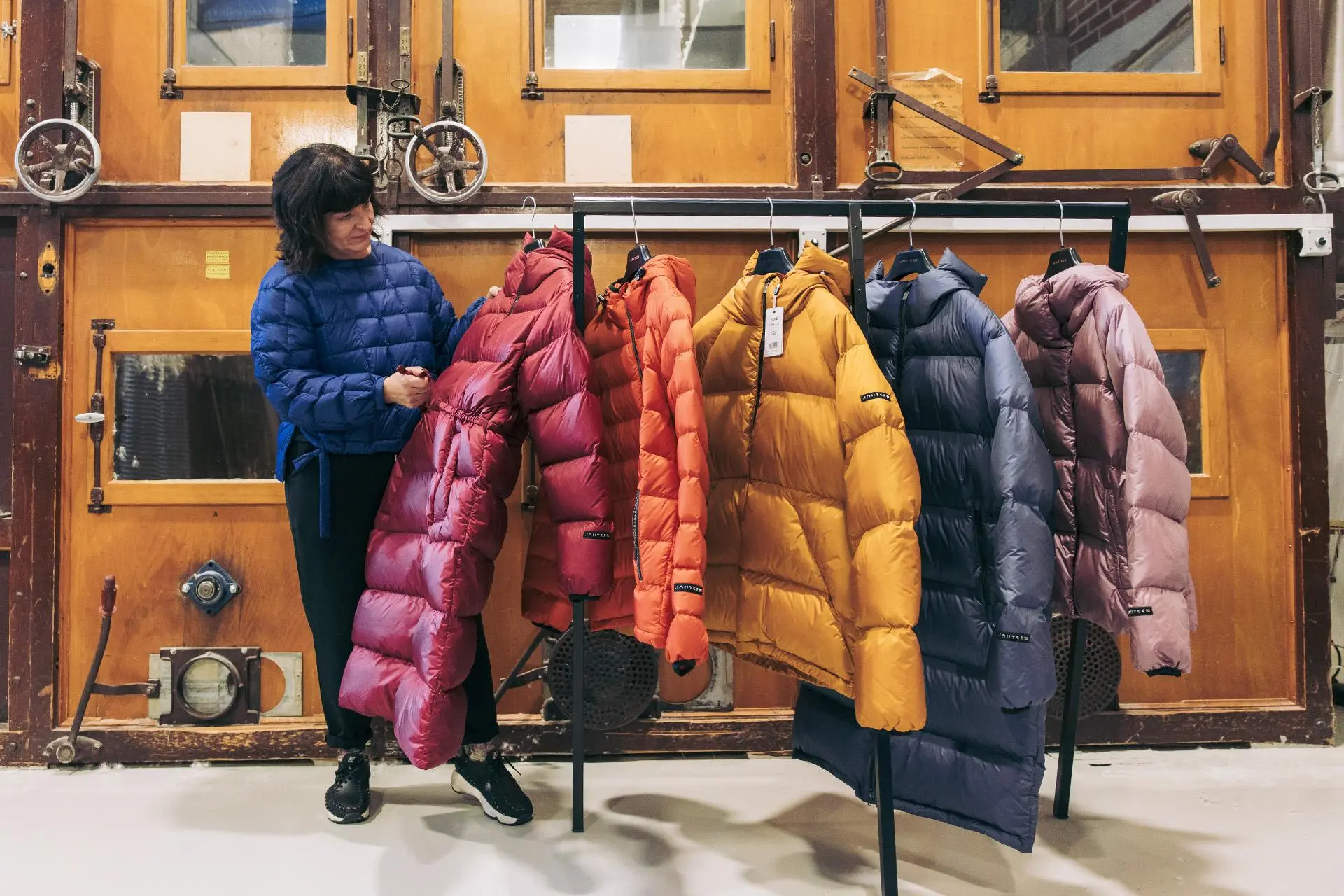 Katja Helén katselee untuvatakkeja tehdassalissa