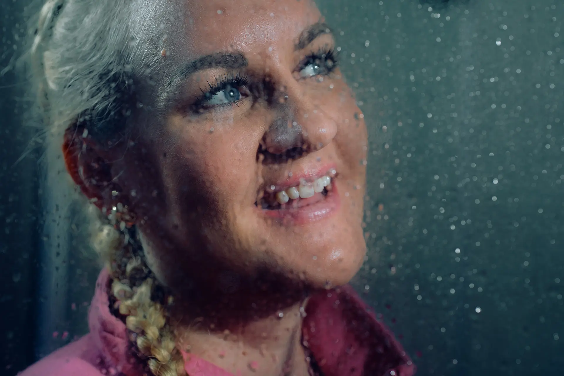 Lähikuva Auri Kanasesta lasin läpi, jossa on vesipisaroita.