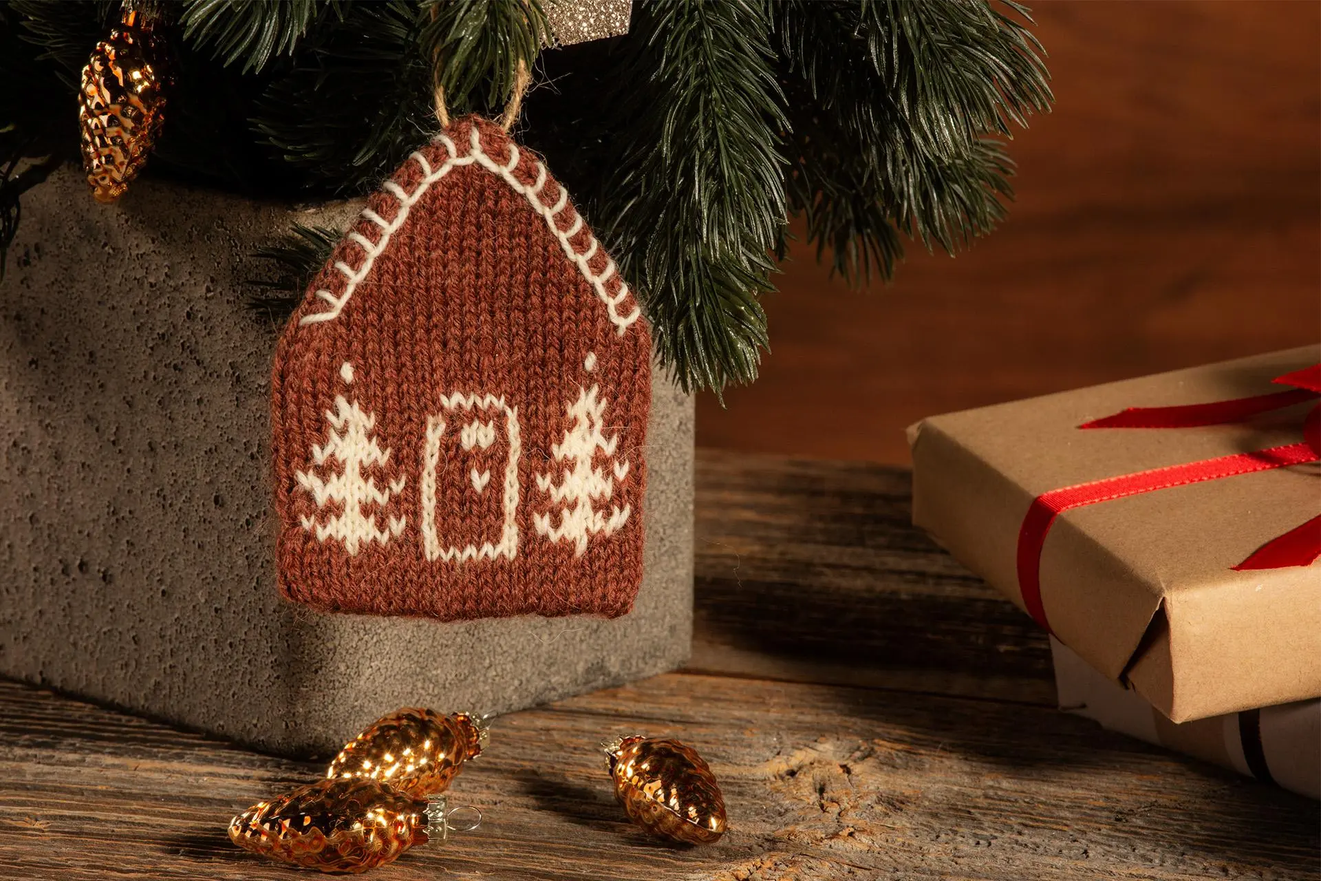 Neulottu joulukoriste, joka muistuttaa piparkakkutaloa.