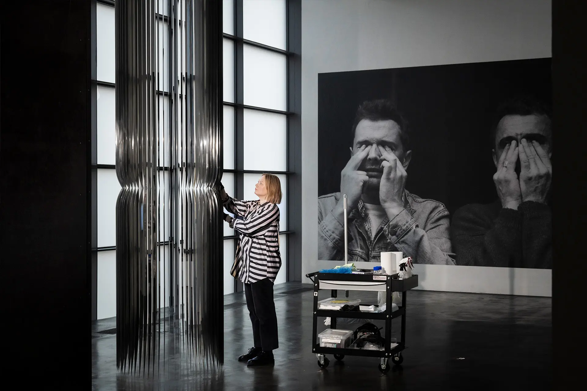 Konservaattori Liisa Vesa pyyhkii pölyjä taideteoksesta Kiasmassa.