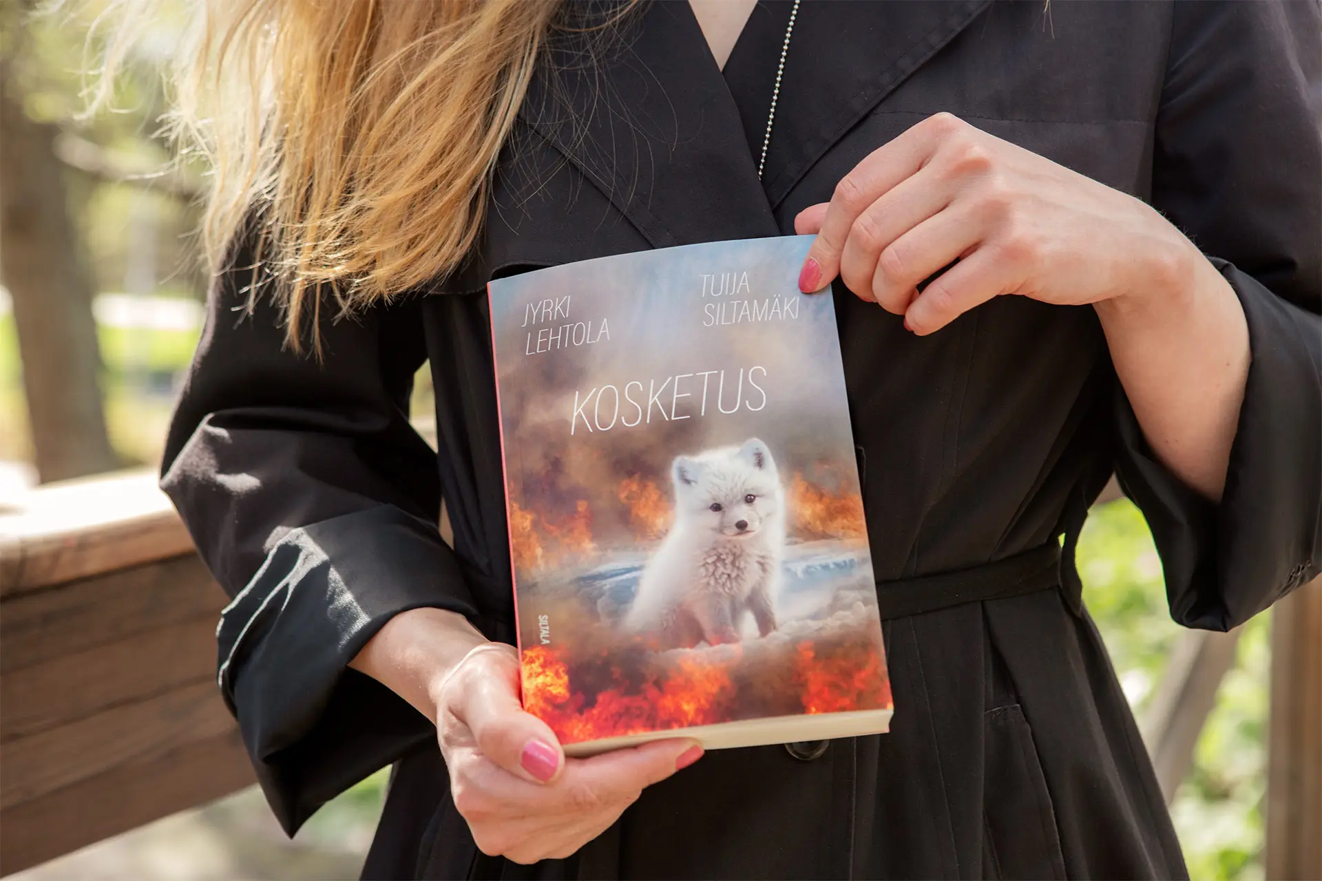 Lähikuva Tuija Siltamäen käsistä, jotka pitelevät Kosketus-kirjaa.