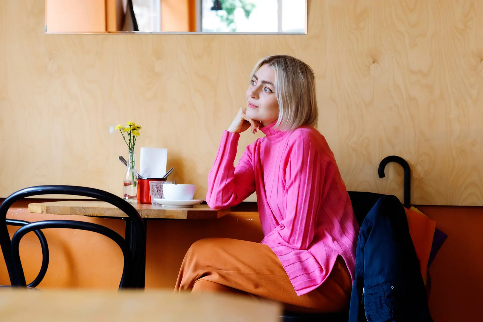 Jenni Rotonen istuu kahvilassa.