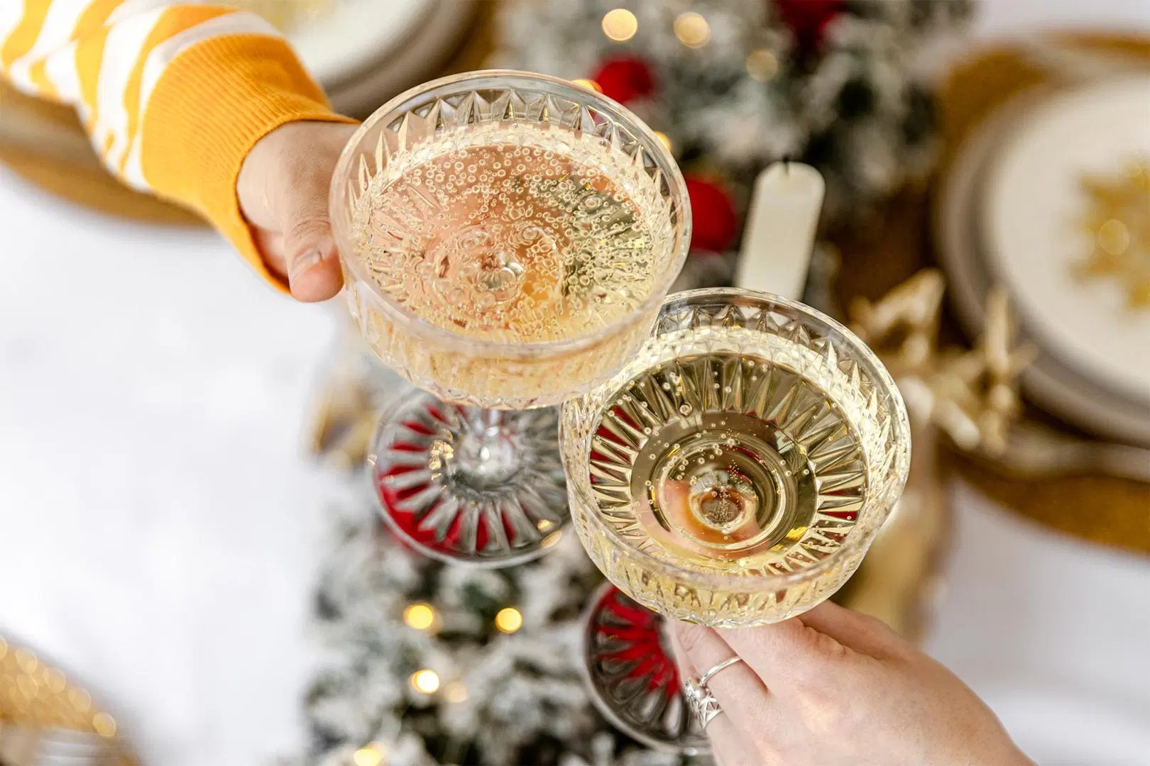 Juomalaseja kilistetään yhteen, laseissa vaaleaa juomaa.