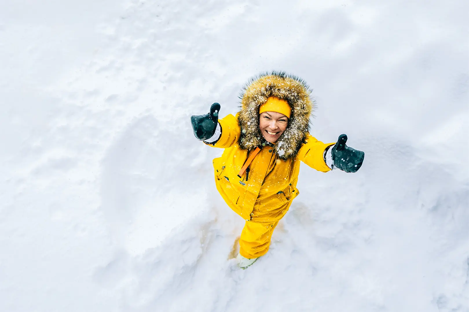 Nainen kurottaa talvella taivaalle.