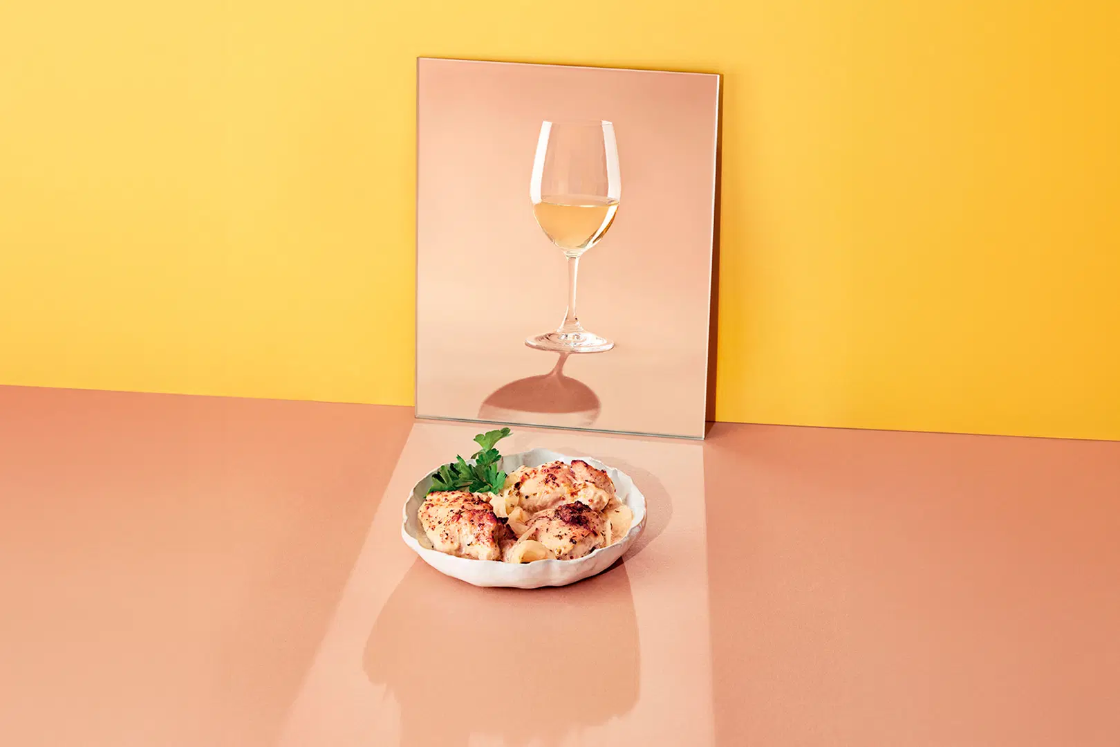 Kermainen kana-annos lautasella, vieressä lasillinen Sauvignon Blanc -viiniä.