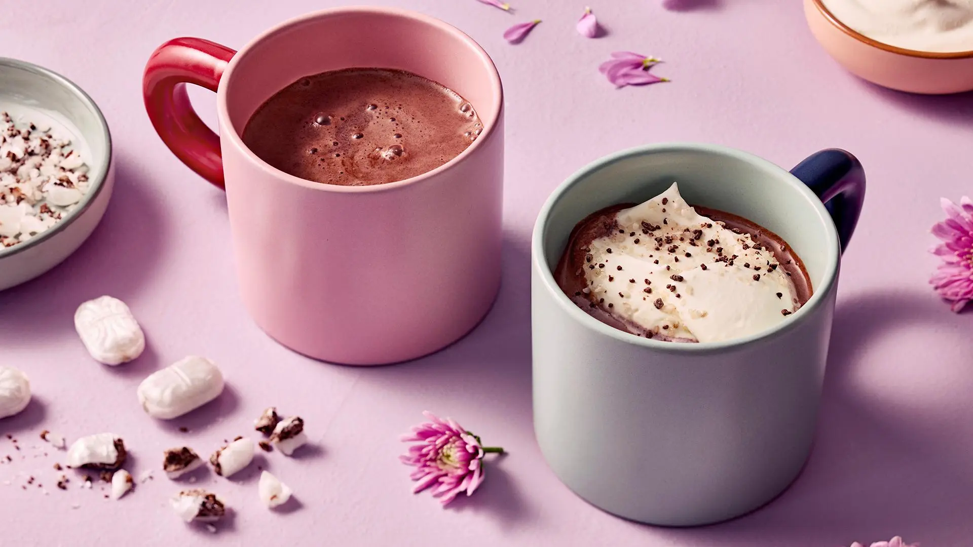 Kaksi kuppia kaakaota, toinen kermavaahdolla.