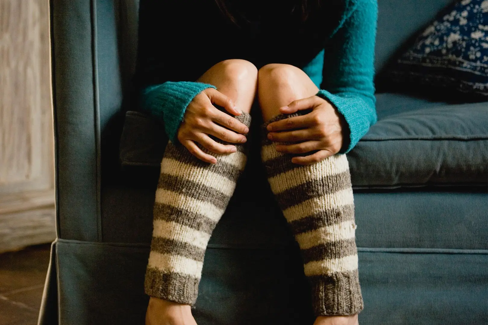 Sohvalla stuvan naisen jalat, joissa on raidalliset sääystimet