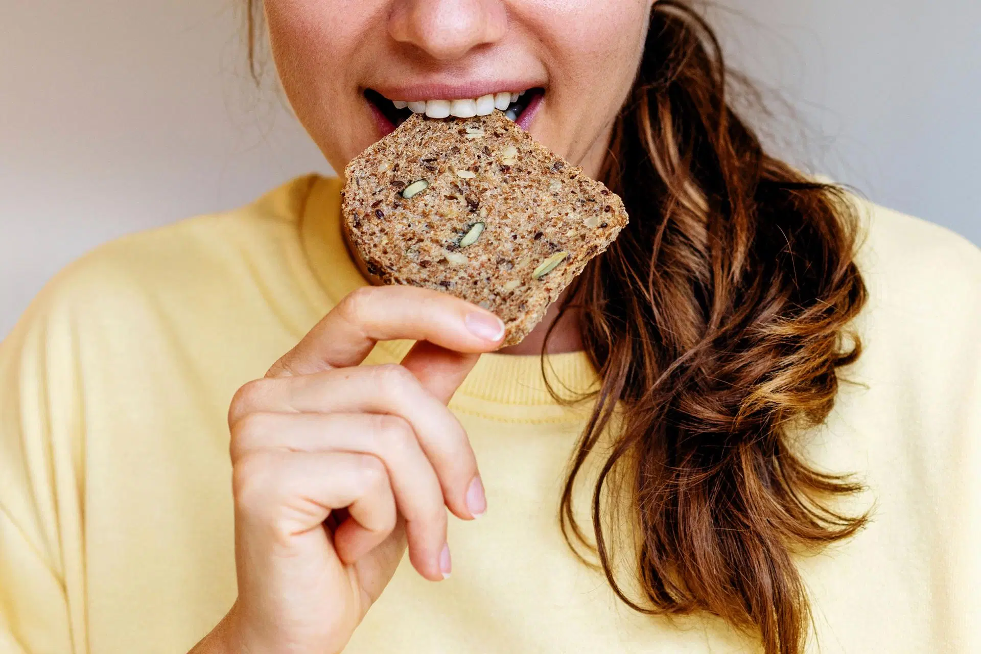 Nainen haukkaa ruisleipää