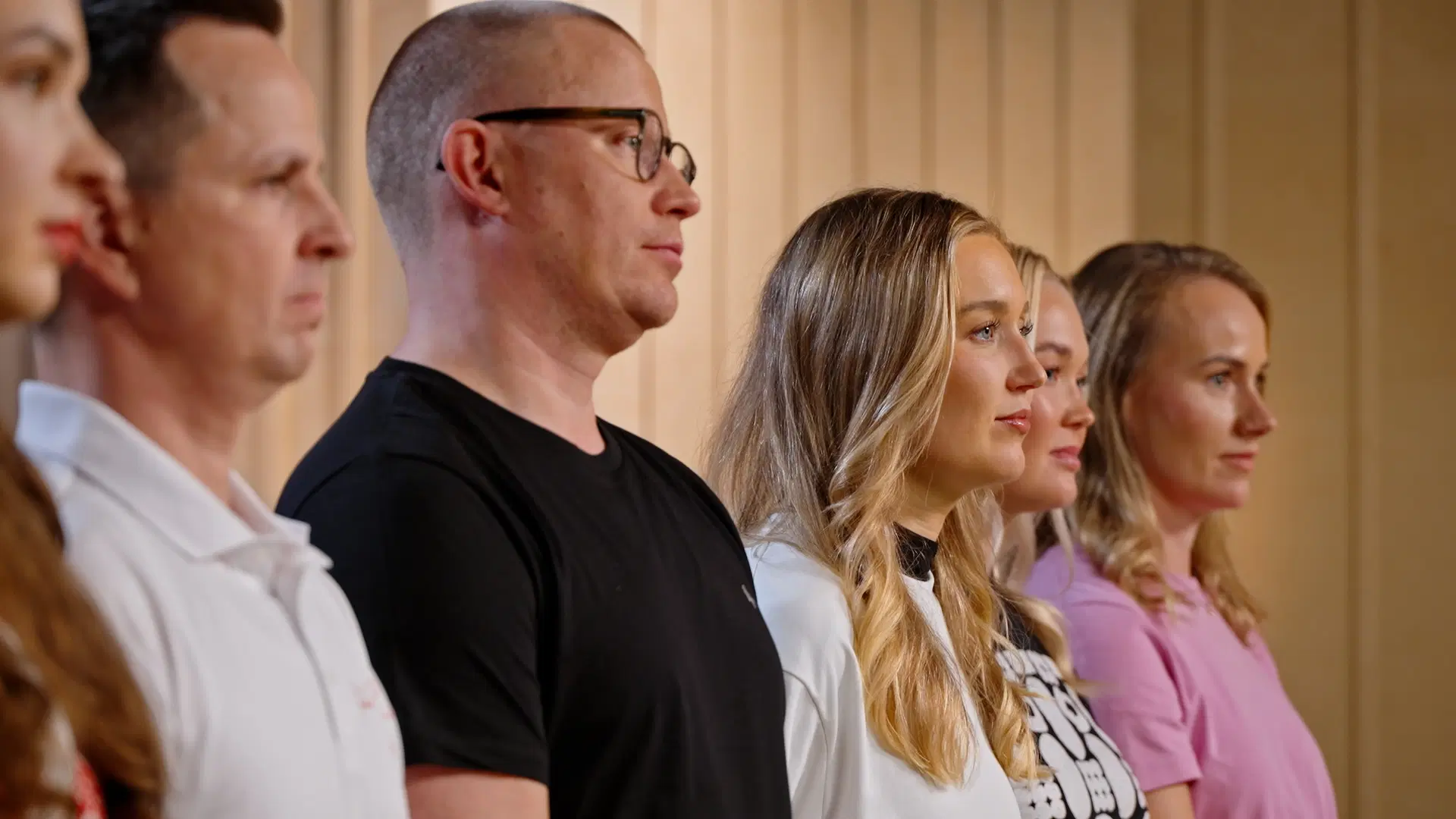 Kilpailun finalistit seisovat totisina rivissä.