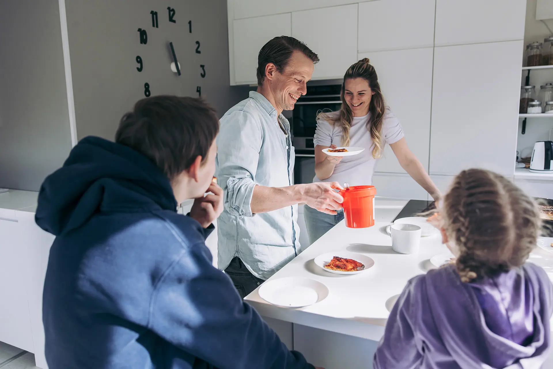 Konsta ja Aami Hietanen keittiössä valmistamassa lettuja, etualalla kaksi lasta selin kameraan.