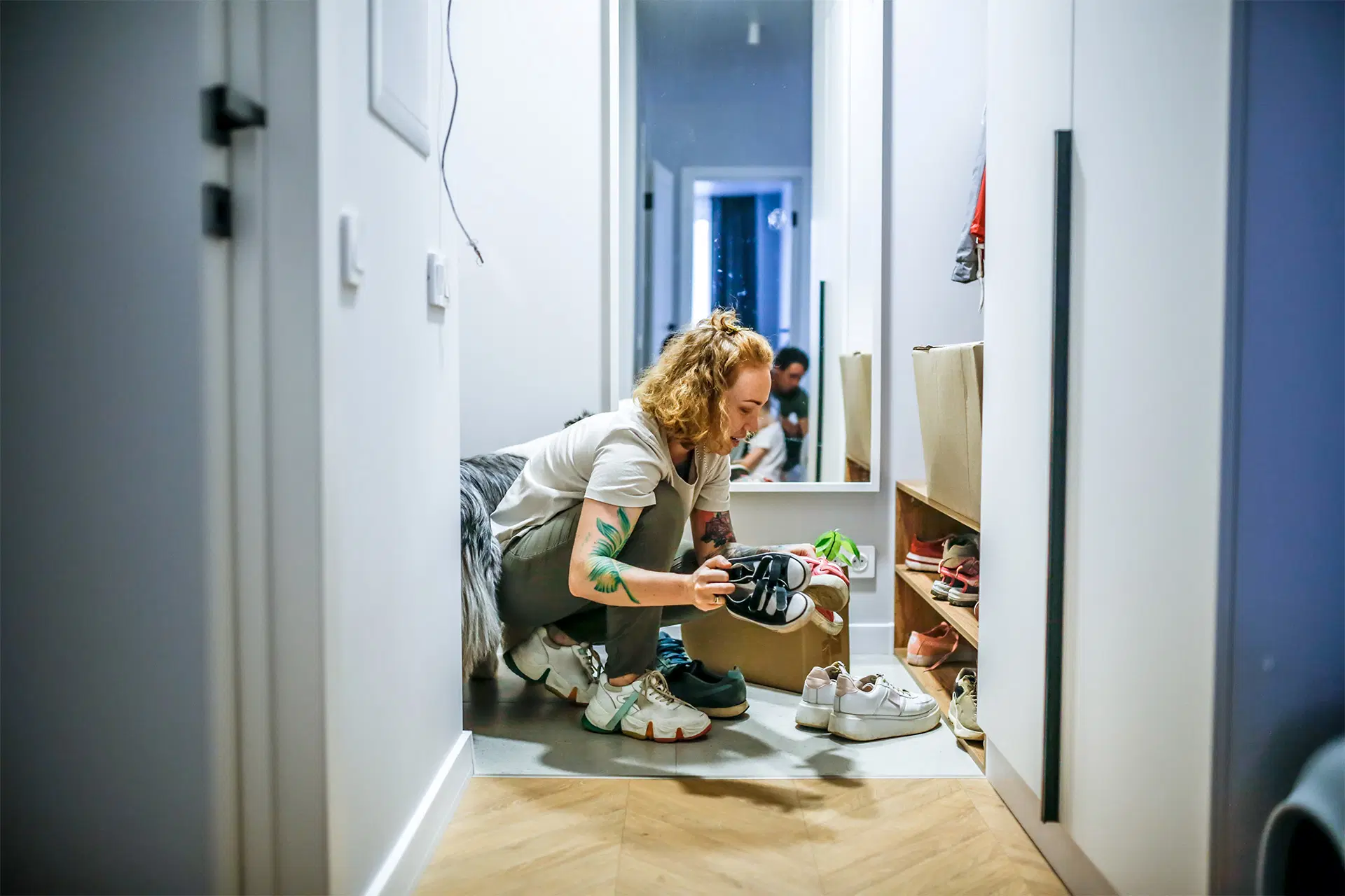 Nainen siivoaa kapeassa eteisessä.