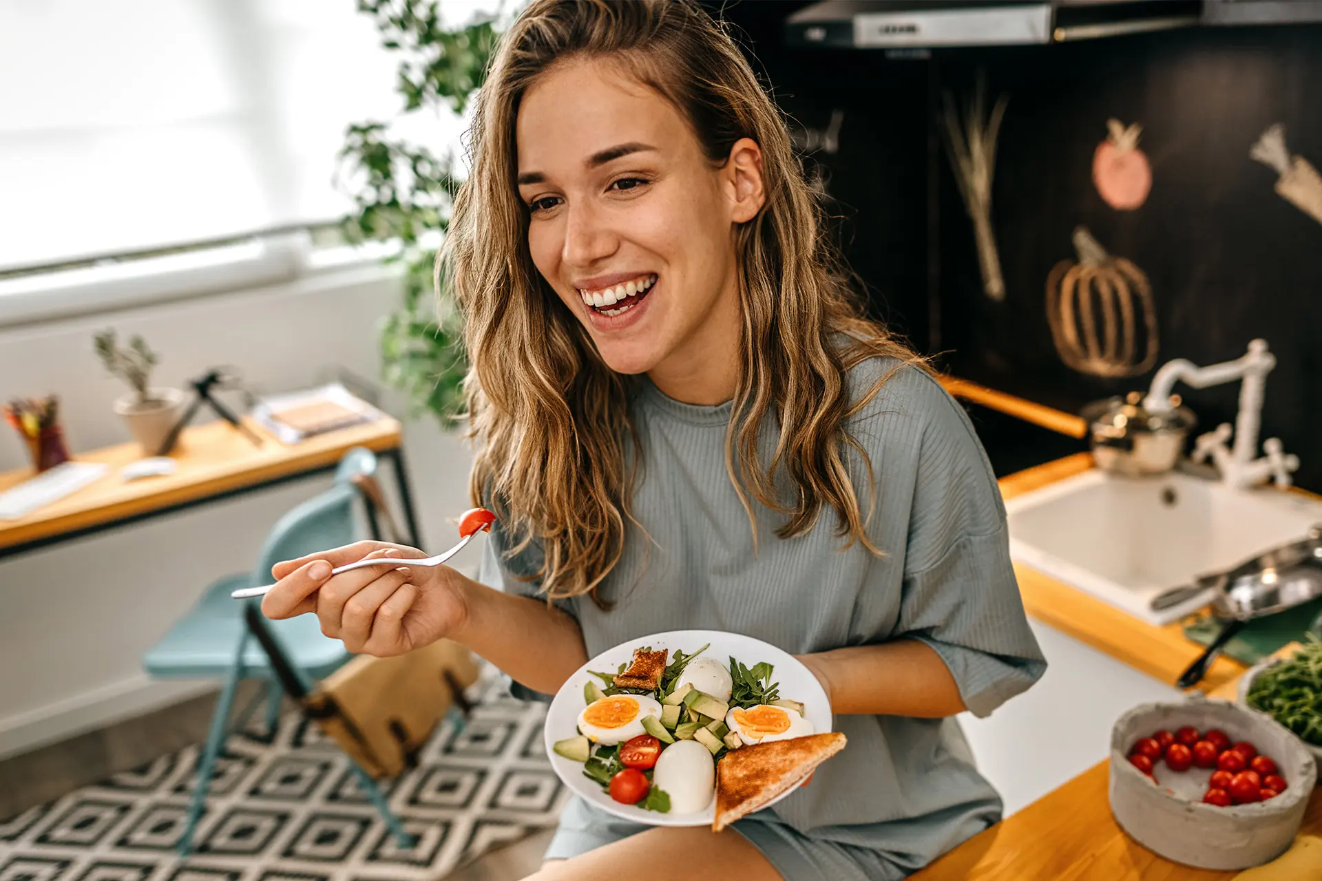Nainen syö, lautasella esimerkiksi kasviksia ja kananmunaa.
