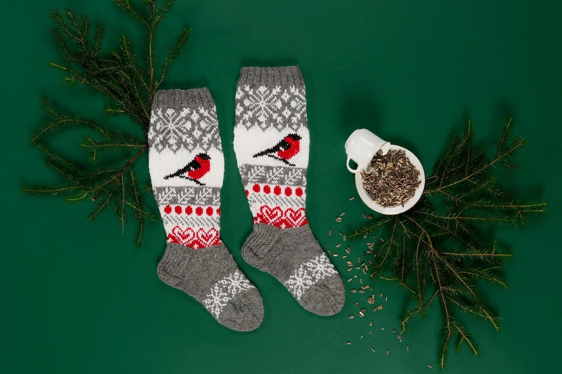 Kymenlaakson maakuntasukat, havuja, kuppi sekä lautanen, jonka päällä on auringonkukansiemeniä.