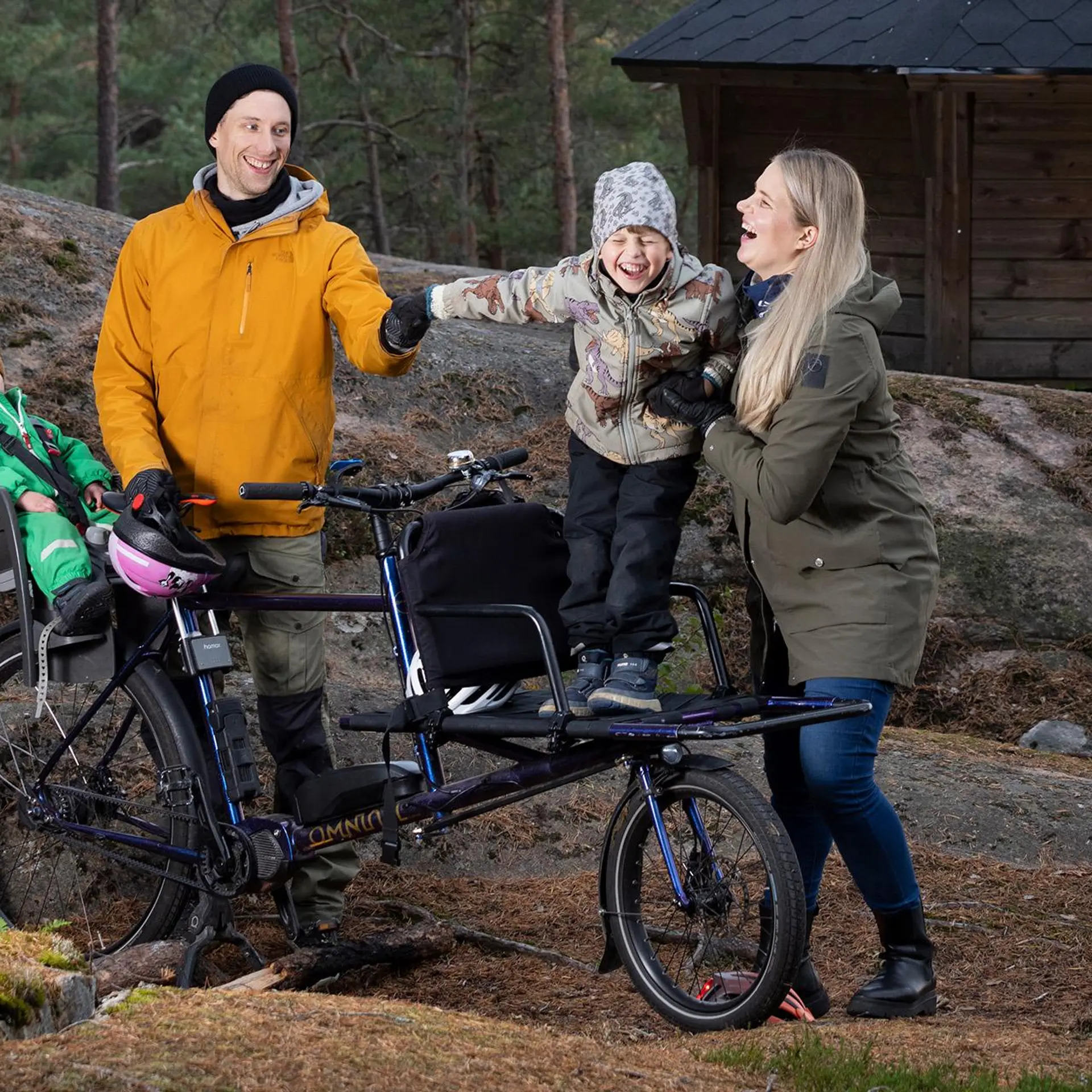 Nelihenkinen perhe tavarapyörän kanssa