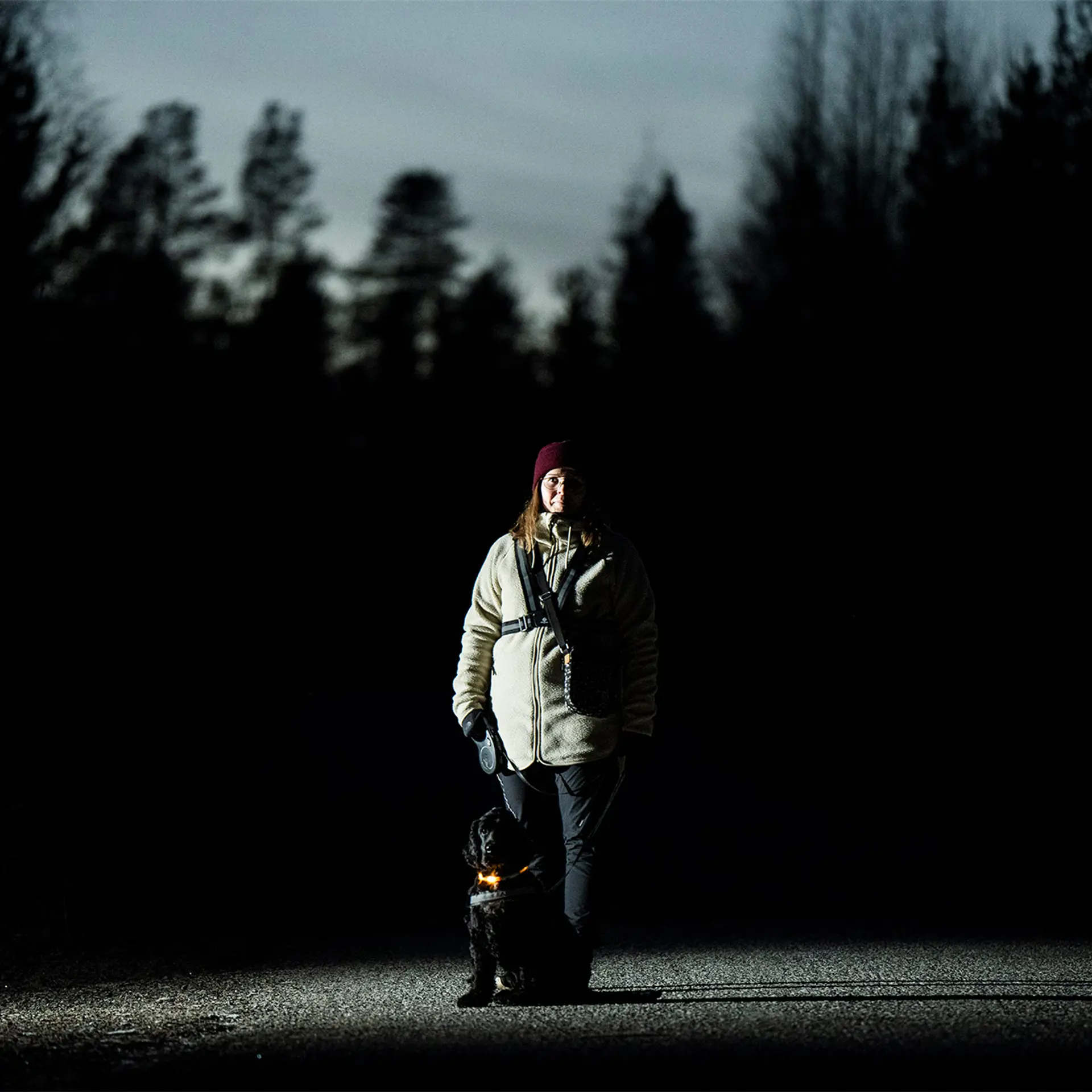 Rovaniemeläinen Mari Laaksonen ulkona pimeässä koiransa Martin kanssa.