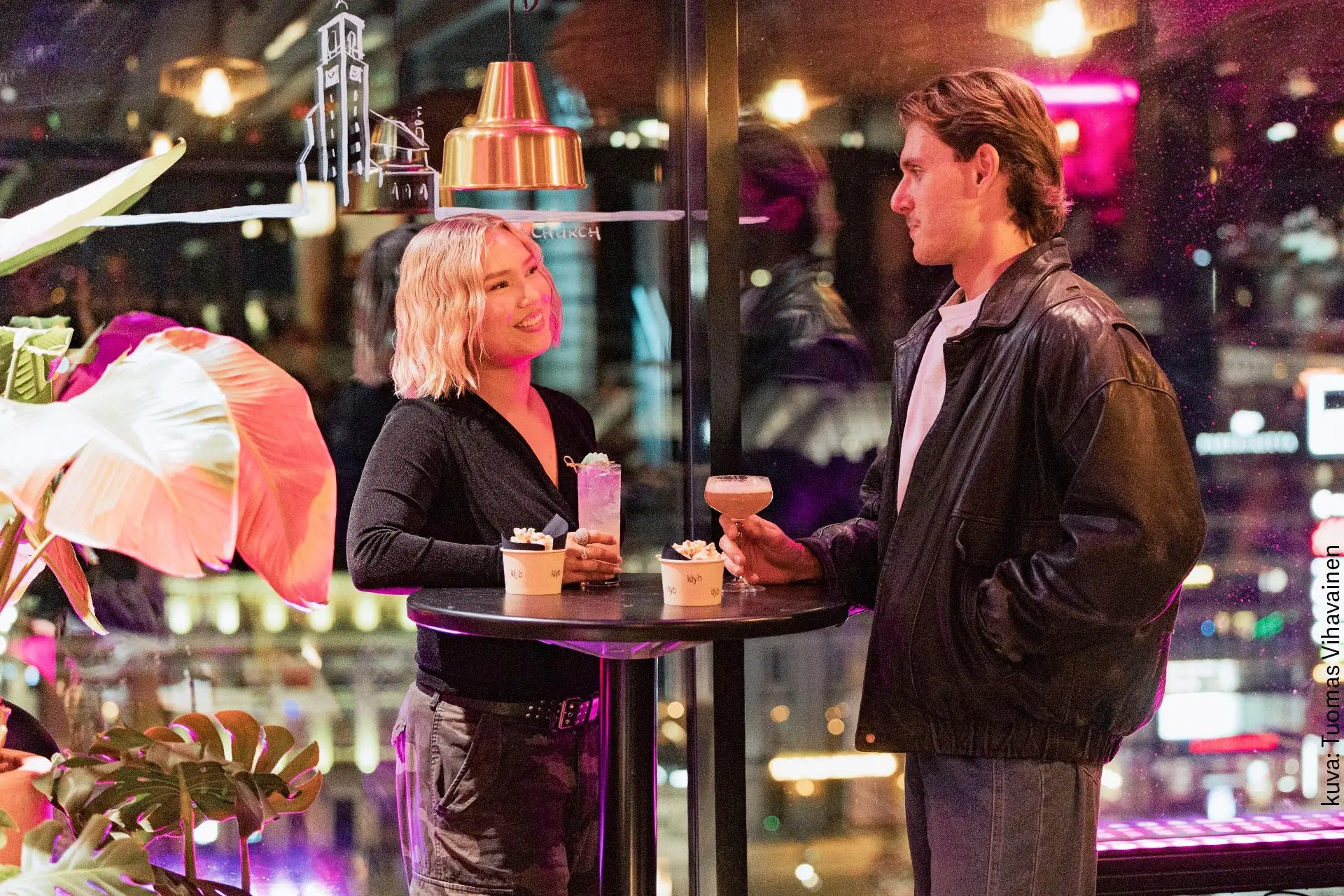 Mies ja nainen juovat drinkkejä ravintolapöydän äärellä