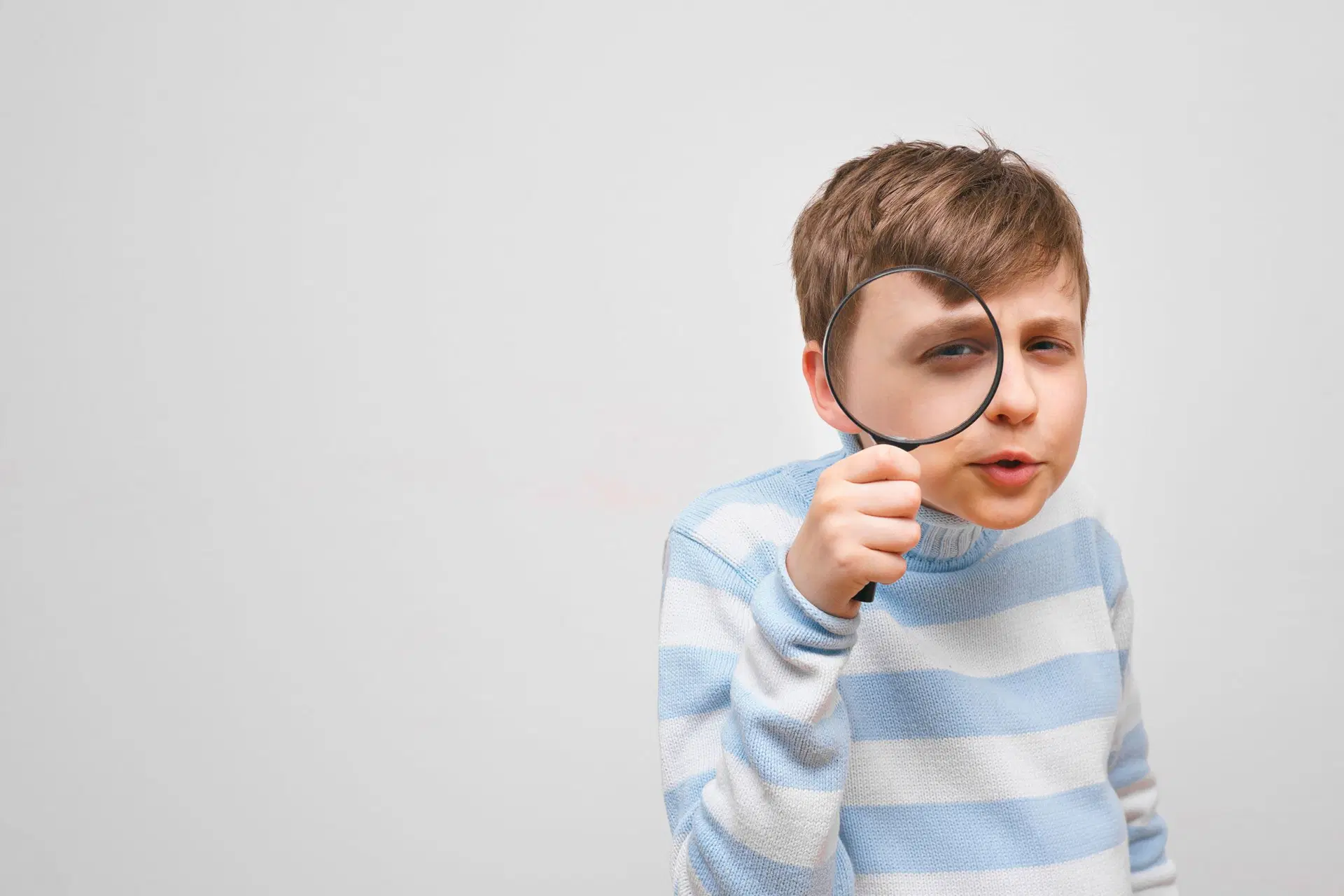 Poika suurennuslasin kanssa.