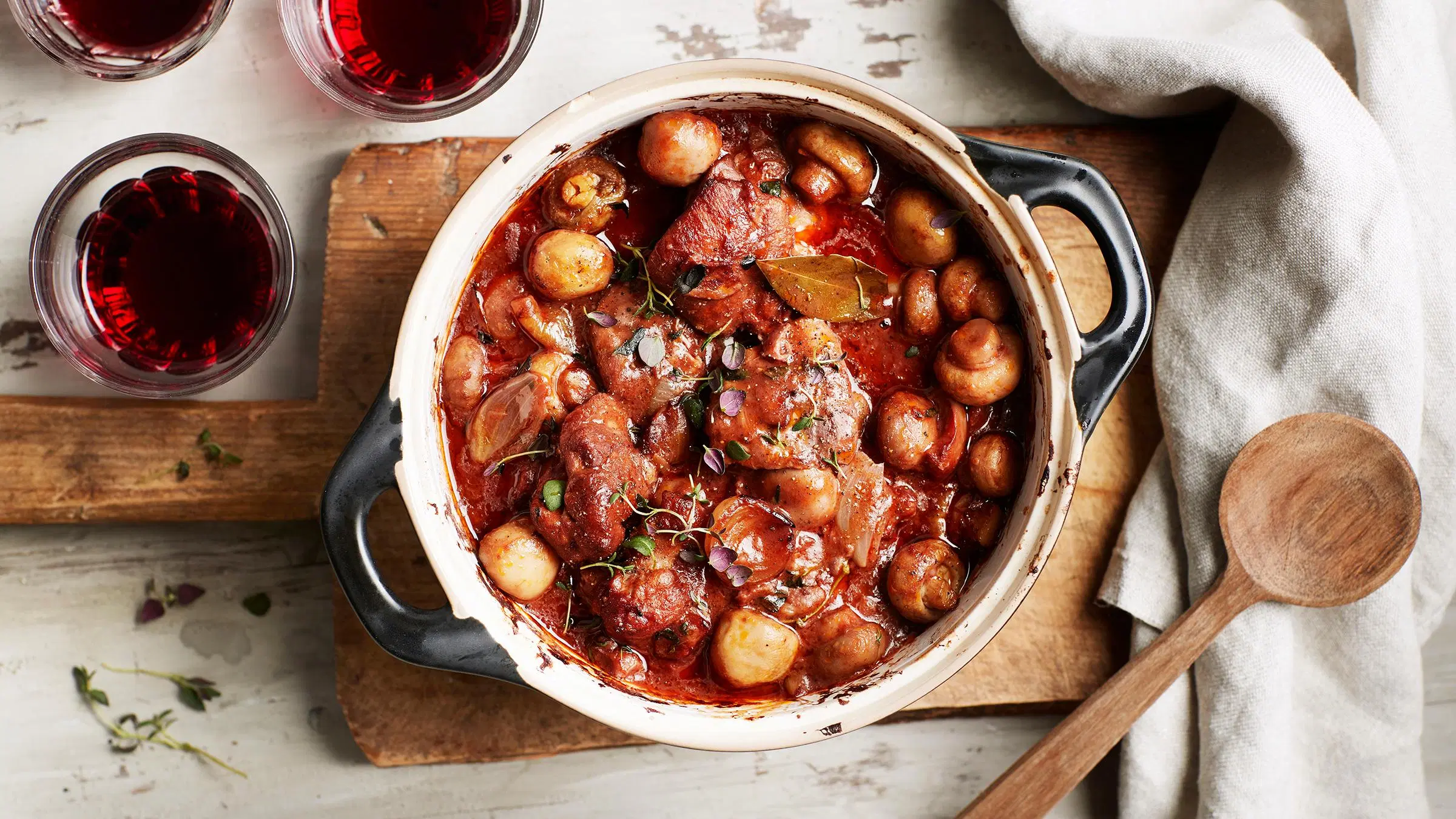 Ranskalainen broileripata, puukauha ja viinilaseja.