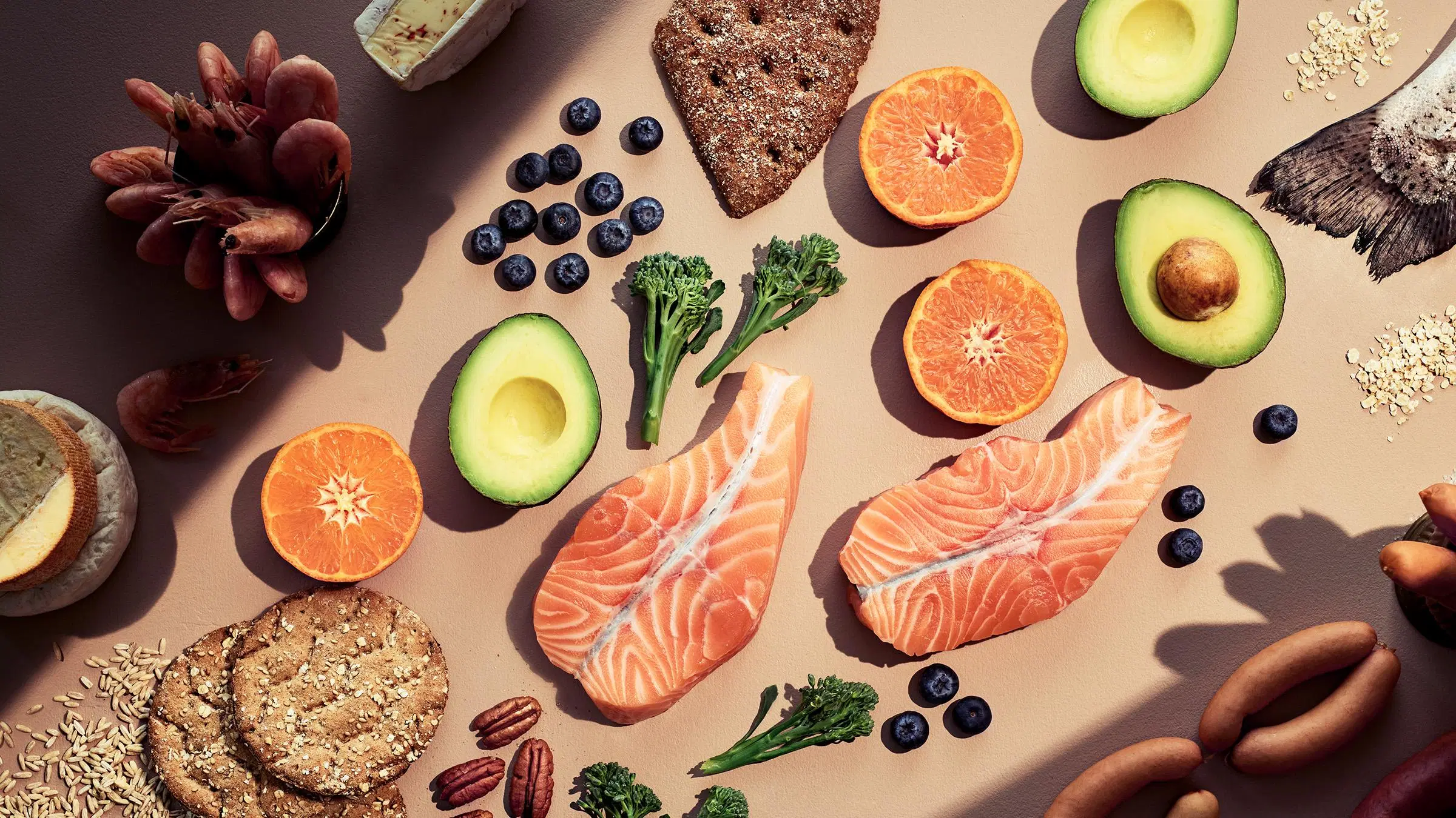 Kolesterolin kannalta suositeltavia ruokia, kuten lohta, kasviksia ja täysjyväleipiä.