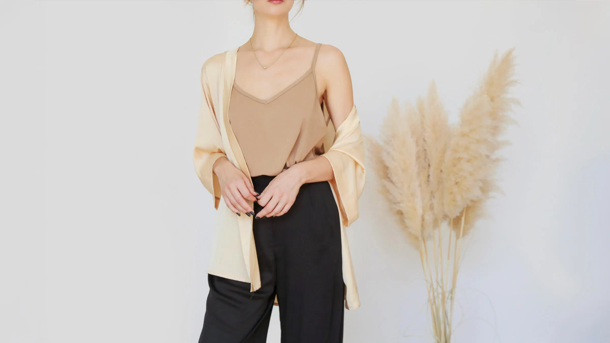 Nainen seisoo taustaa vasten.