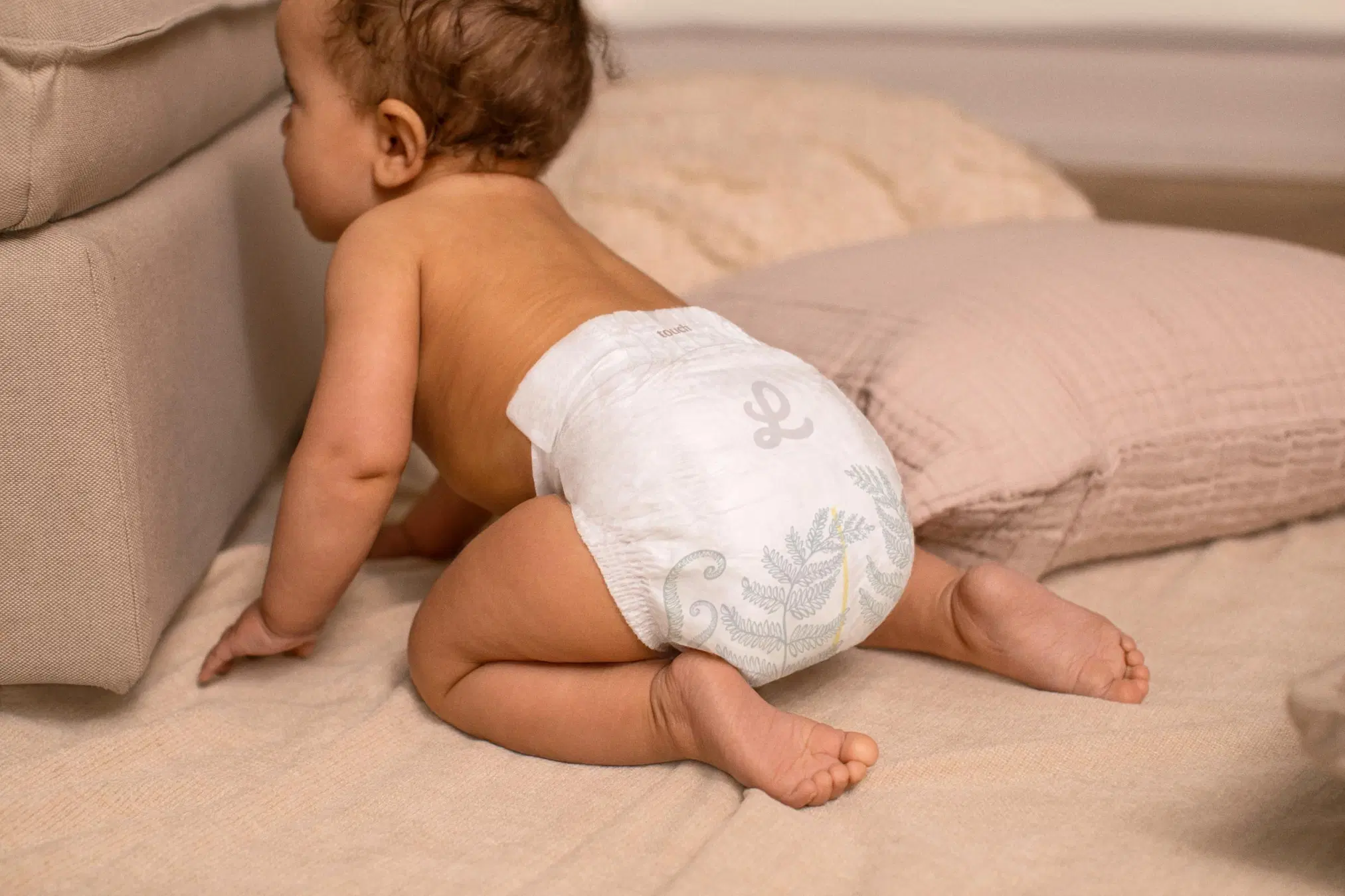 Vauva konttaa pelkkä vaippa päällään